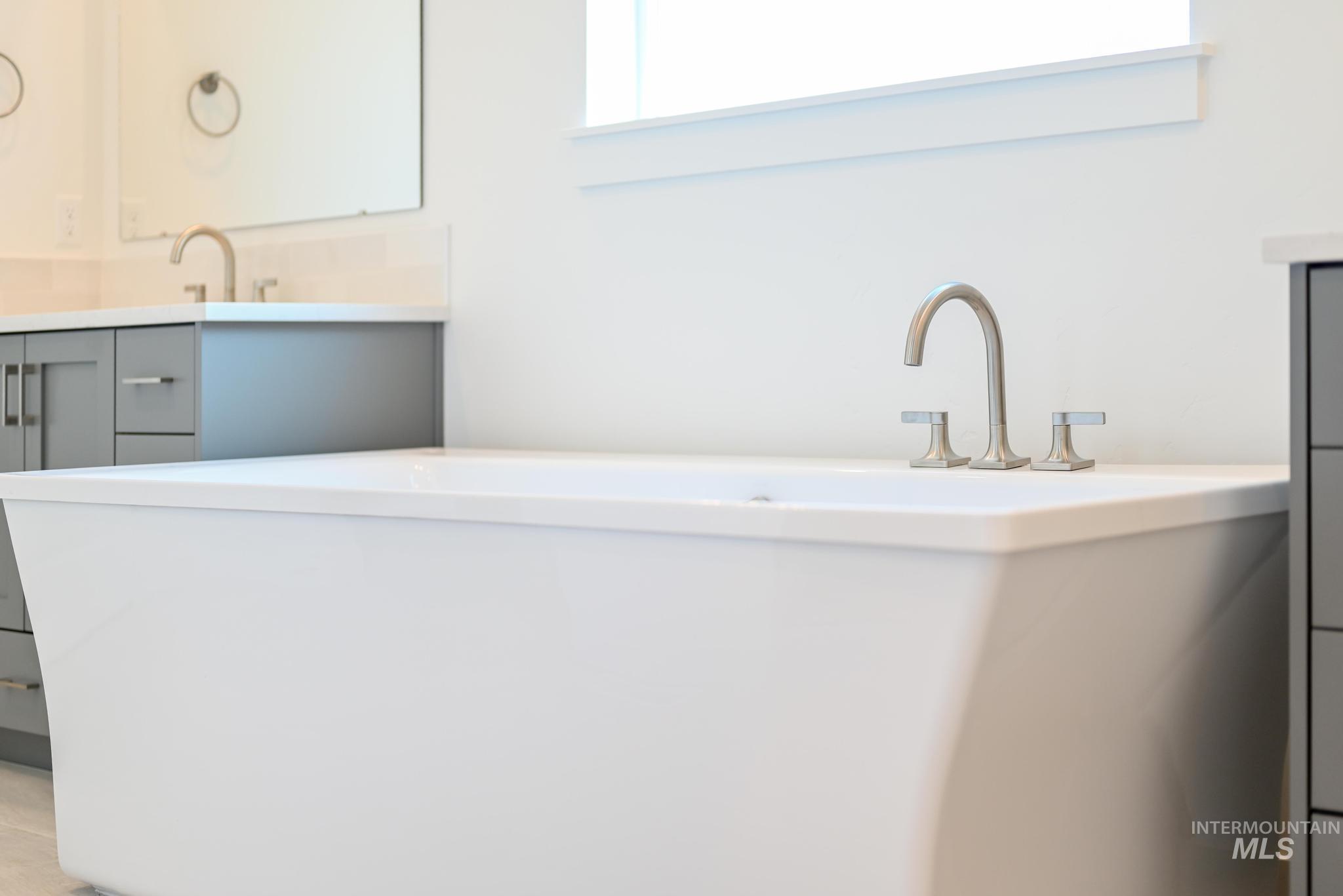 Full bathroom with double vanity and a freestanding tub
