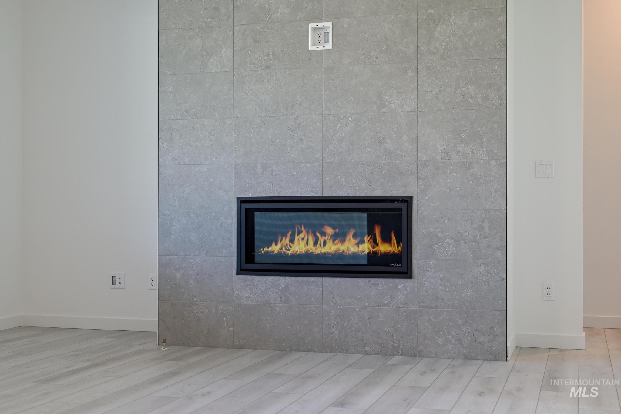 Detailed view of a large fireplace and wood finished floors