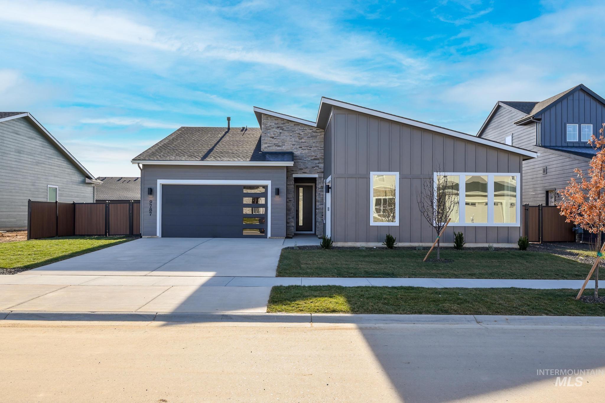 View of front facade featuring board and batten siding, concrete driveway, and an attached garage