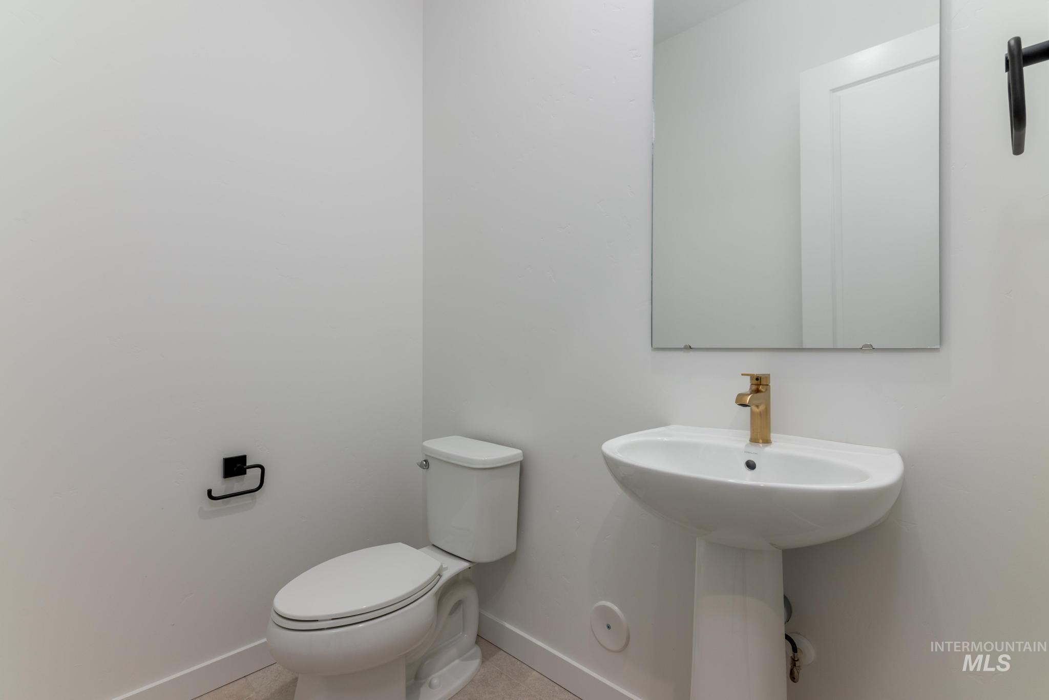 Half bathroom with baseboards and toilet