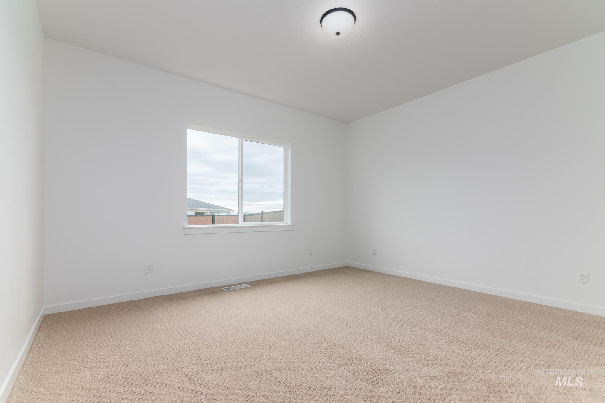 Unfurnished room featuring light carpet and baseboards