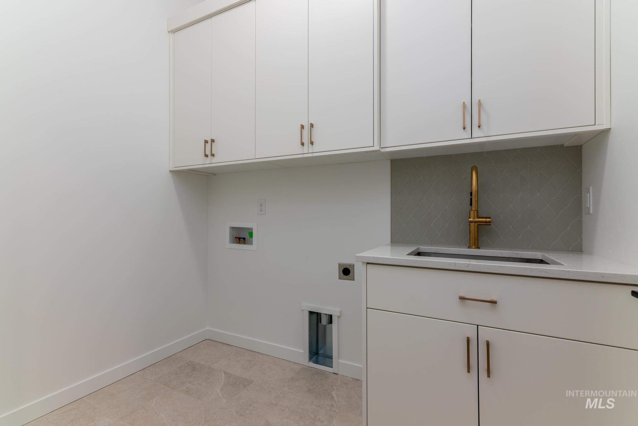 Washroom with washer hookup, hookup for an electric dryer, and cabinet space