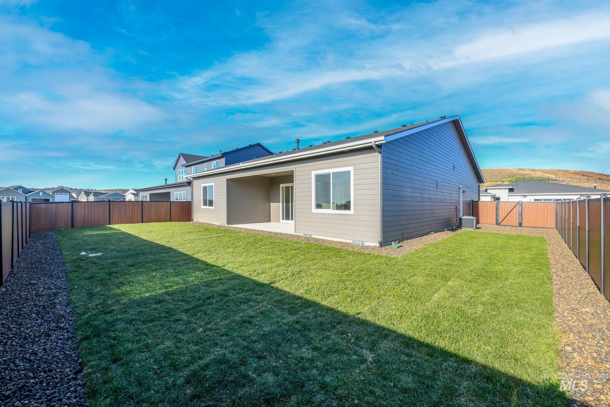Rear view of property with a patio, a fenced backyard, and a gate