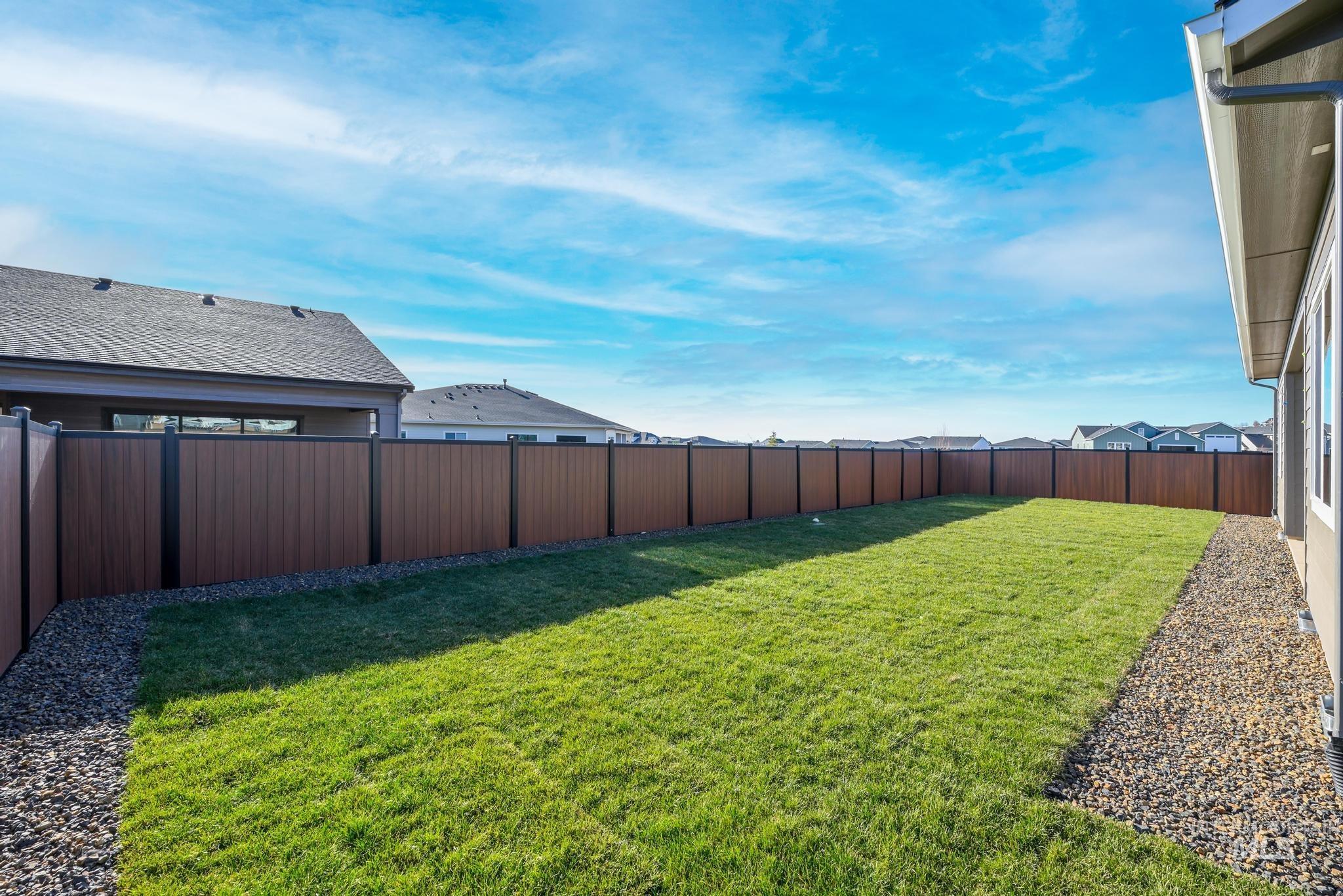 Fenced backyard featuring a residential view