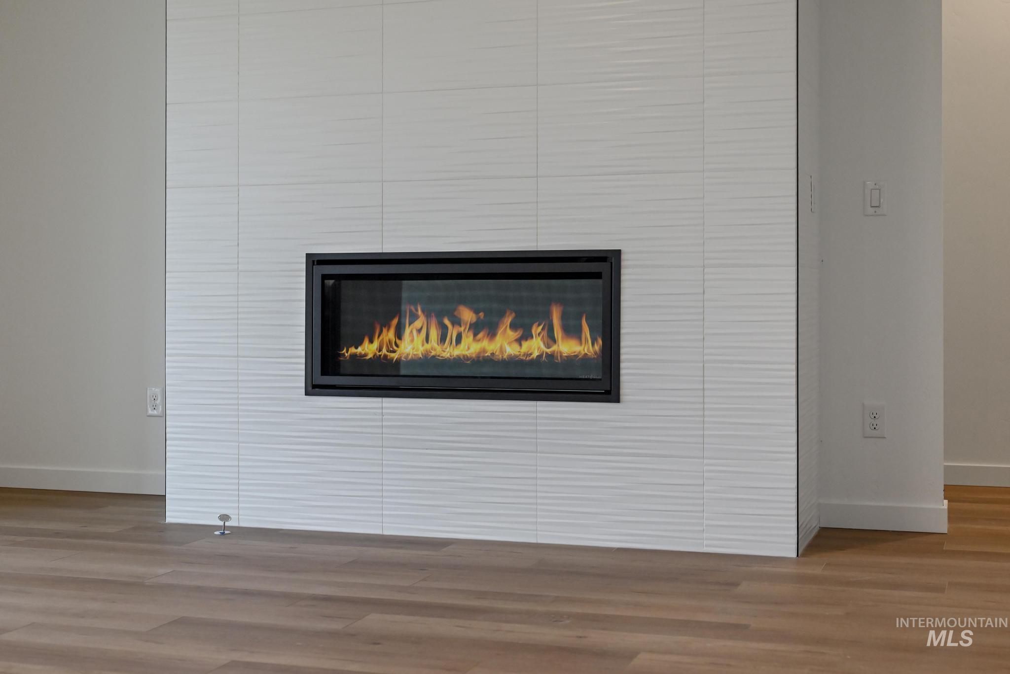 Detailed view of a fireplace and wood finished floors