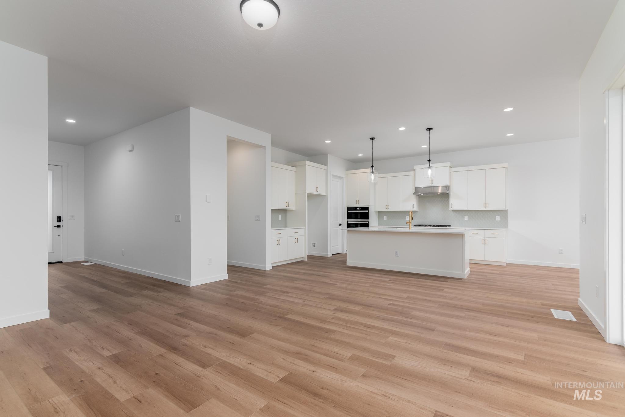 Unfurnished living room with light wood-type flooring and recessed lighting