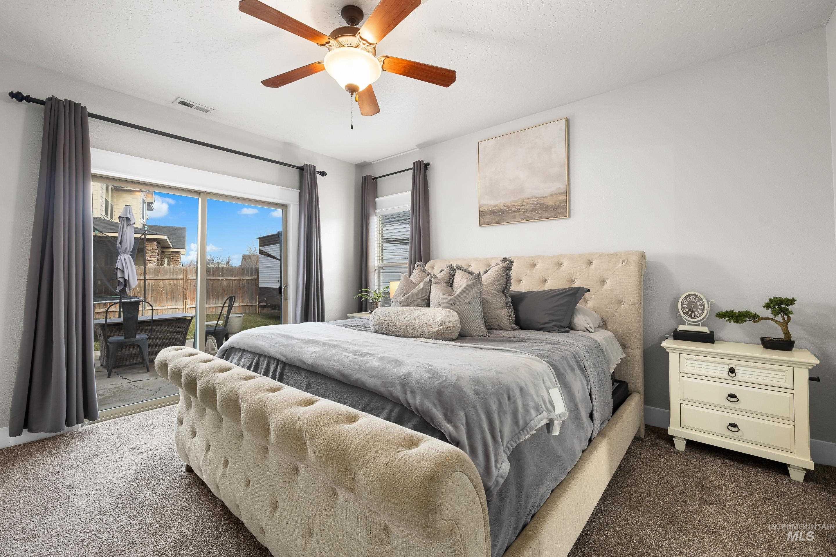 Carpeted bedroom with access to exterior and a ceiling fan