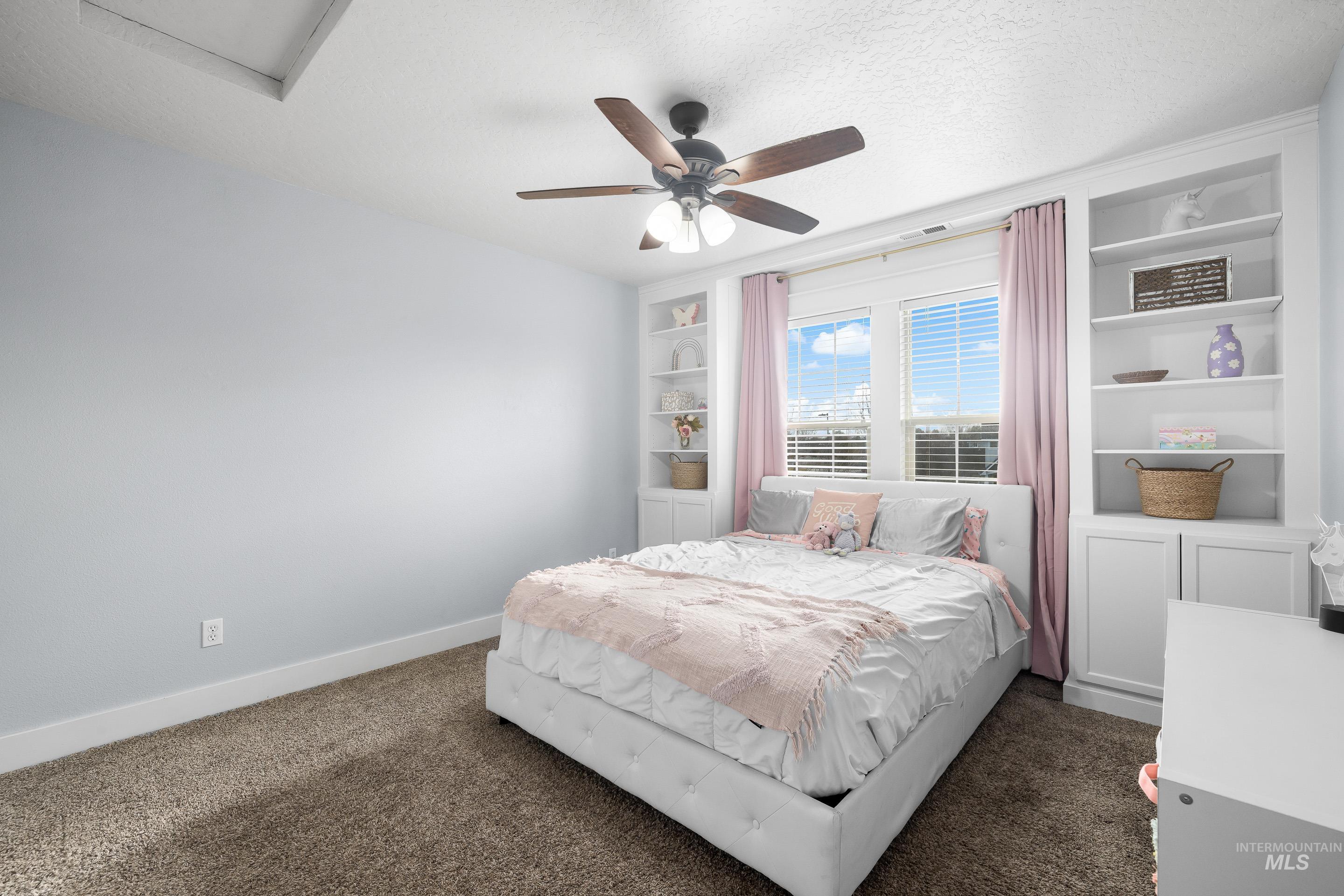 Bedroom featuring ceiling fan, carpet flooring, and a textured ceiling