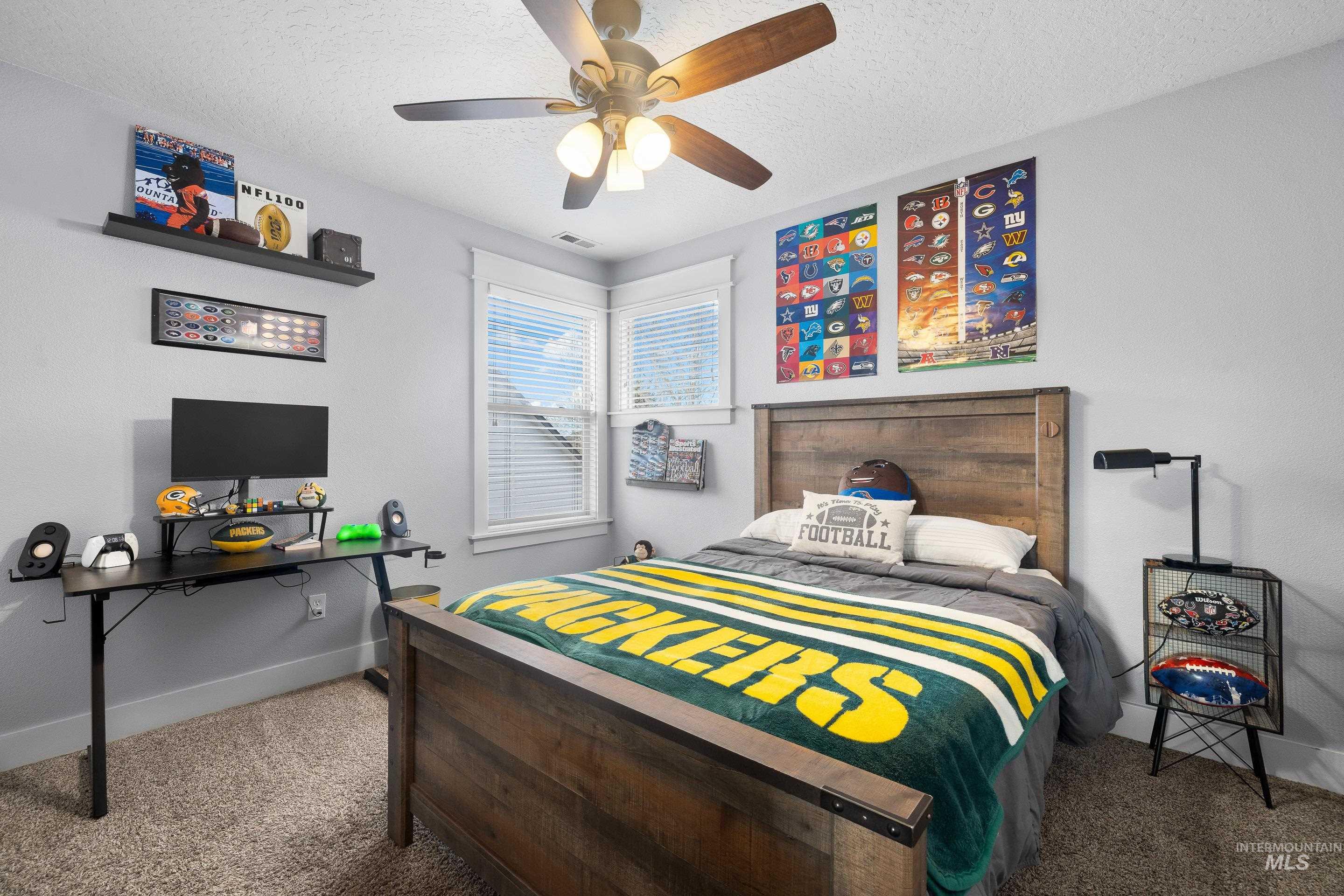 Carpeted bedroom with a textured ceiling and ceiling fan