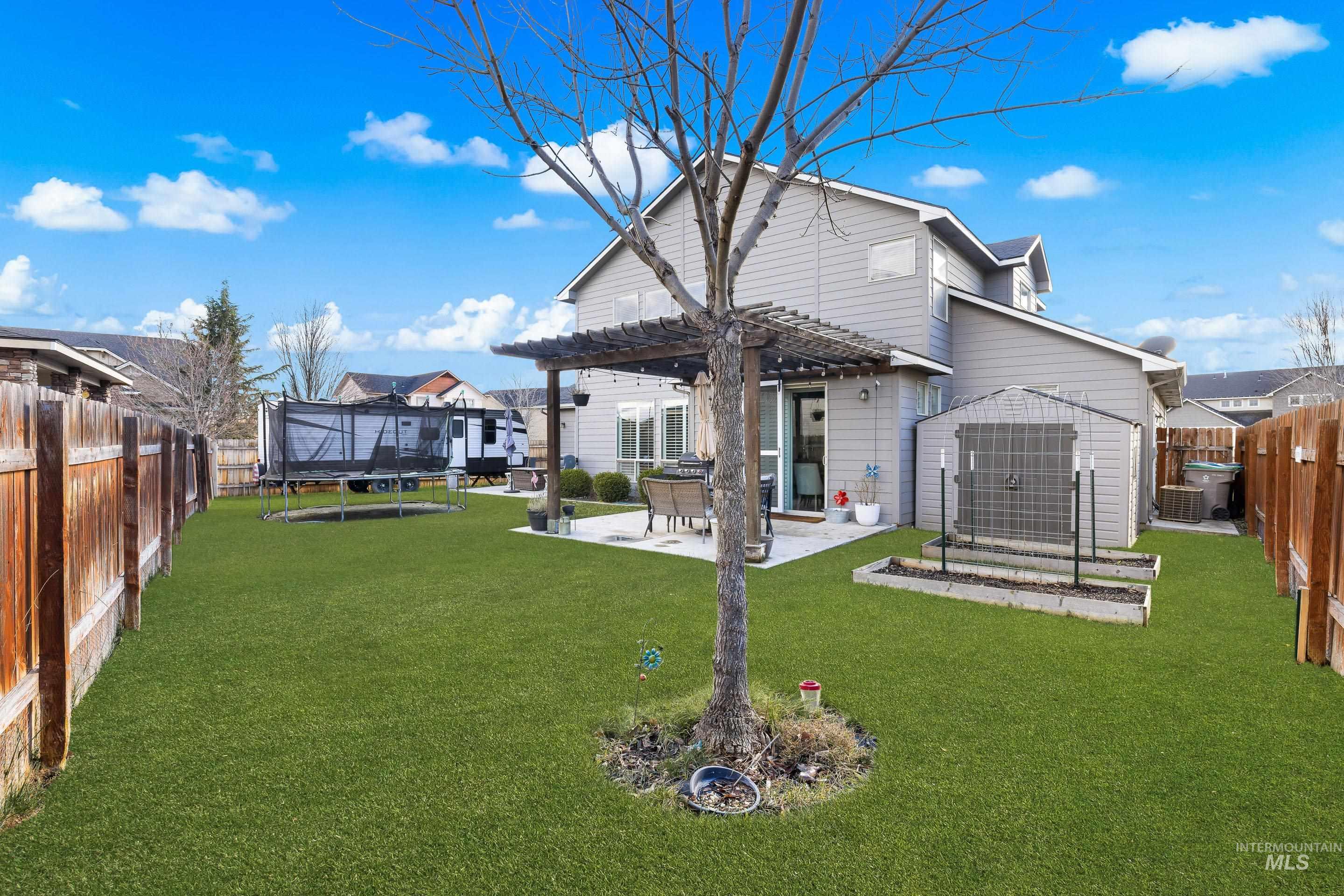 Rear view of property with a fenced backyard, a pergola, a patio, and a trampoline