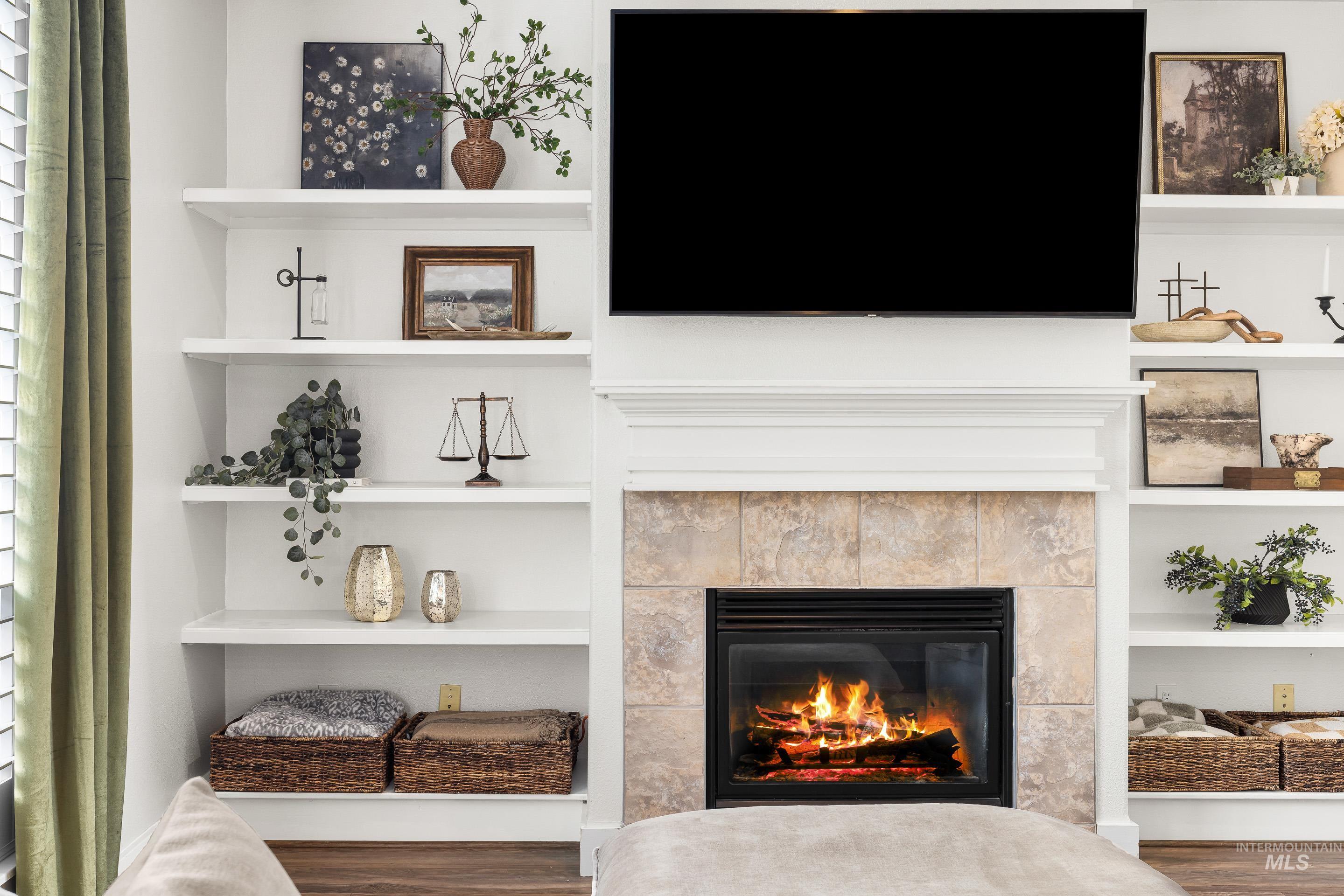 Detailed view of built in shelves, wood finished floors, and a fireplace
