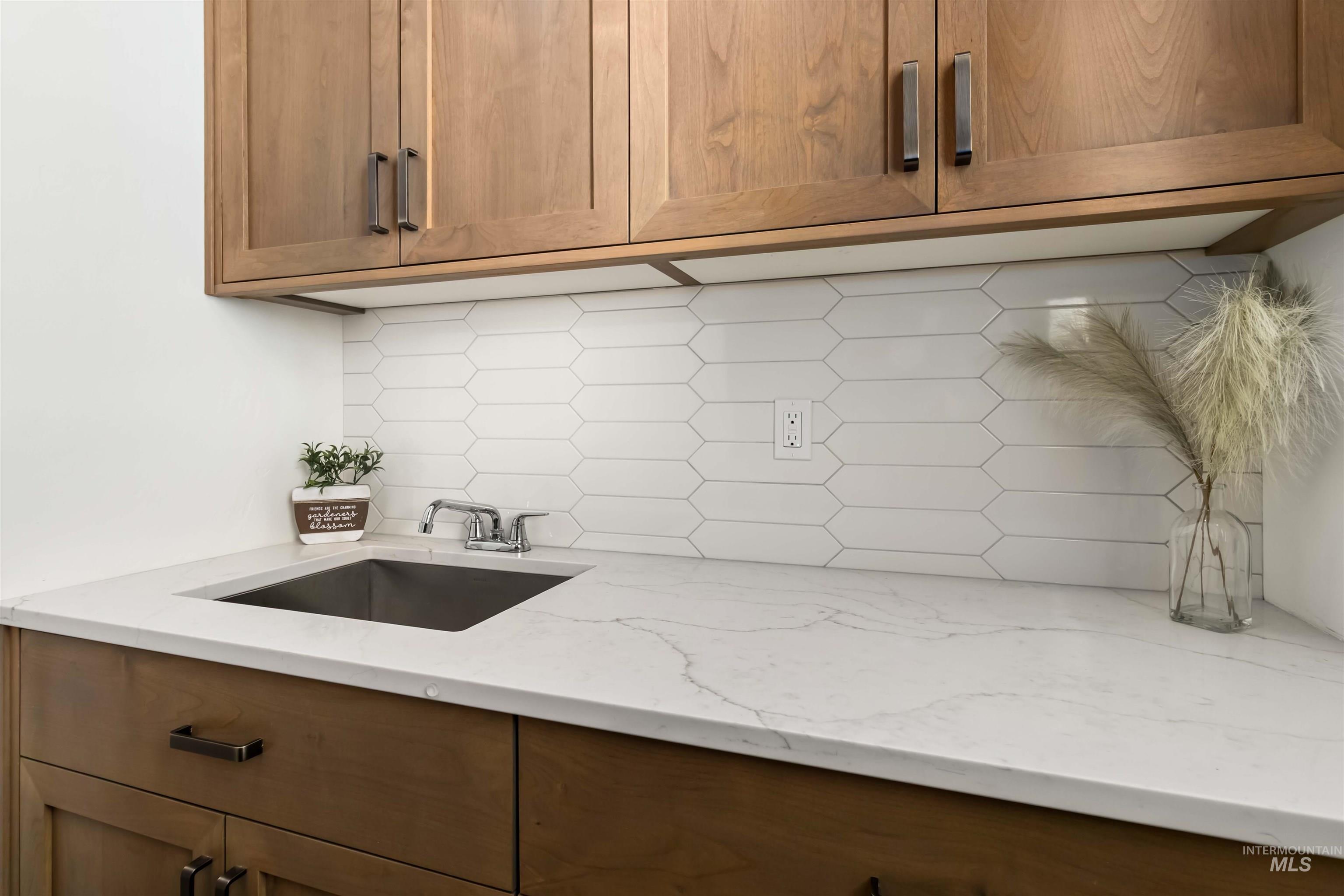 Laundry room featuring sink, over the counter cabinets and folding counter.