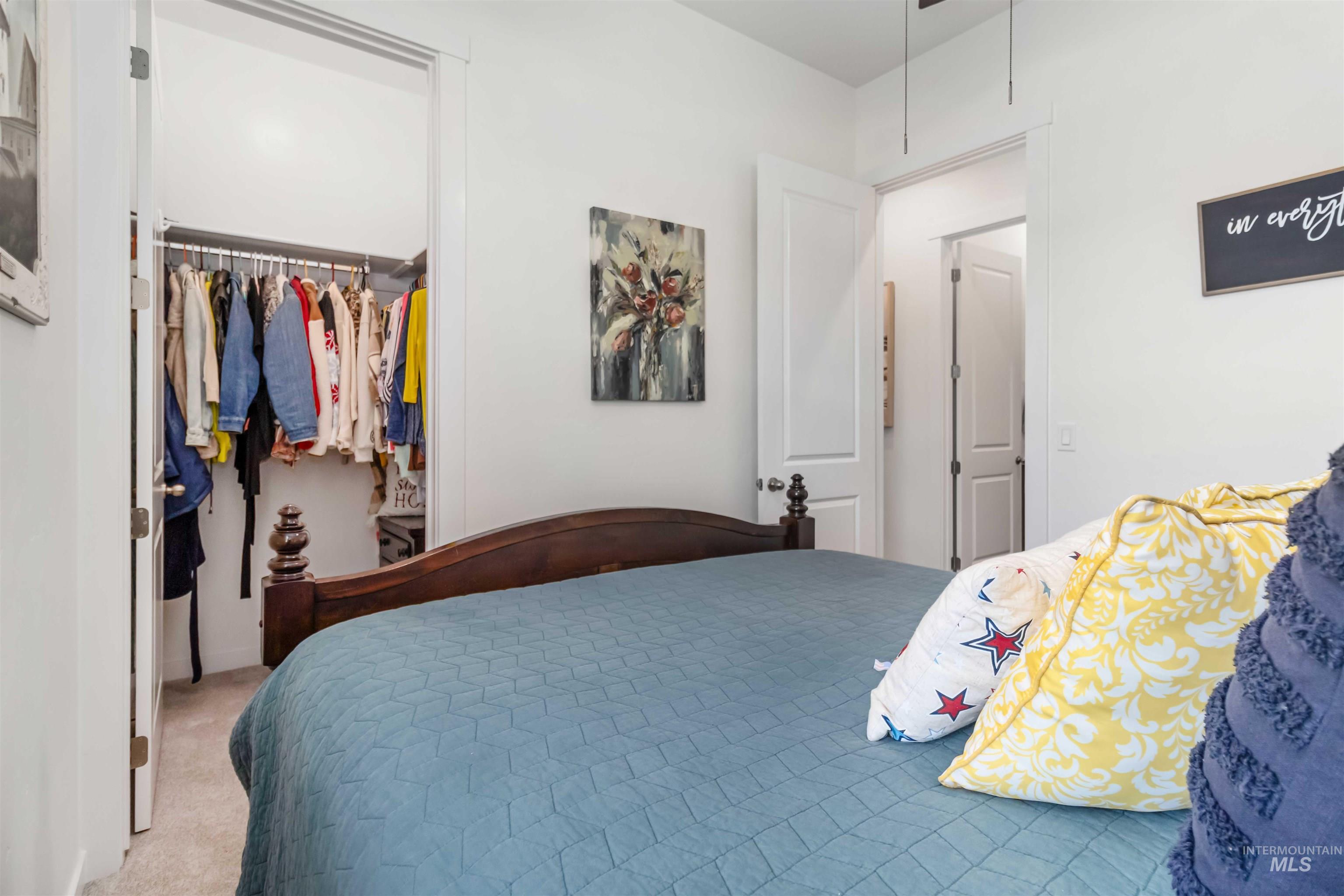 Bedroom with light carpet and large walk in closet