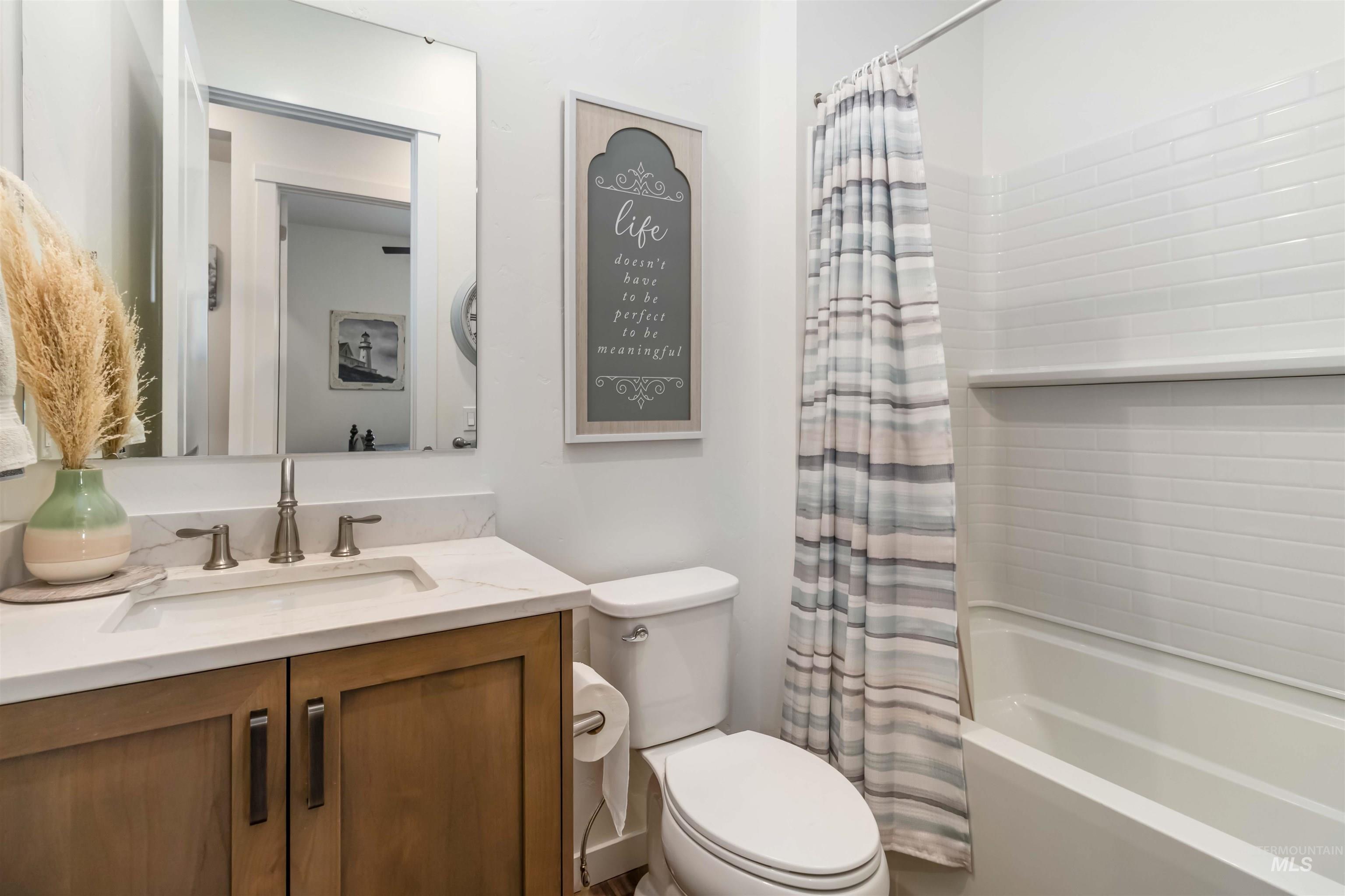 Full bath featuring shower / bath combo and vanity