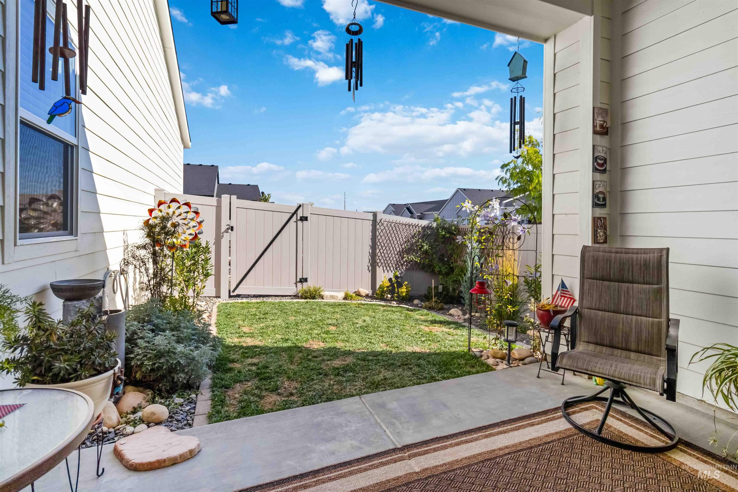 View of covered patio & quaint back yard. This home is on a corner lot with fenced side area.