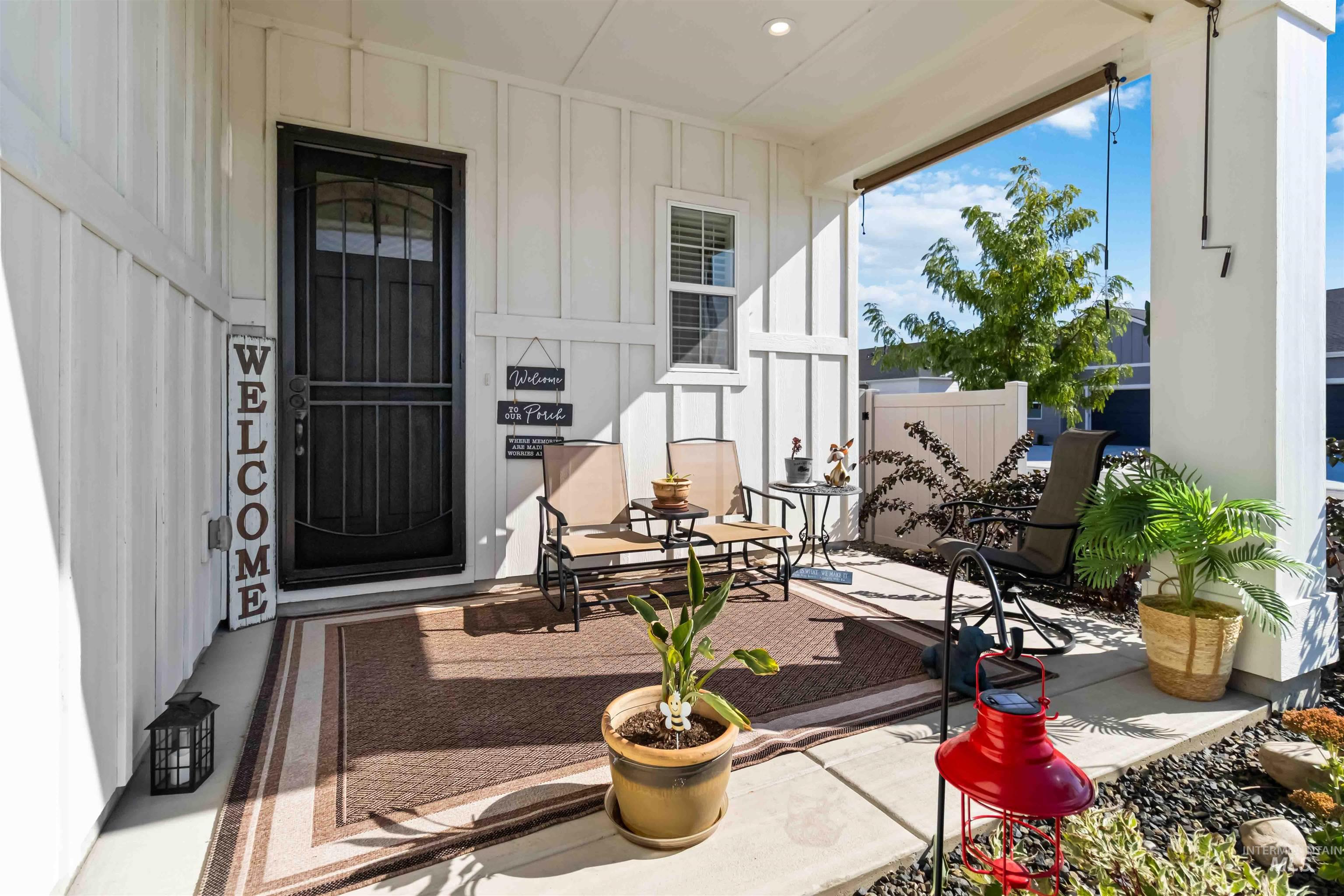Entrance to property with board and batten siding, a porch, and a patio area