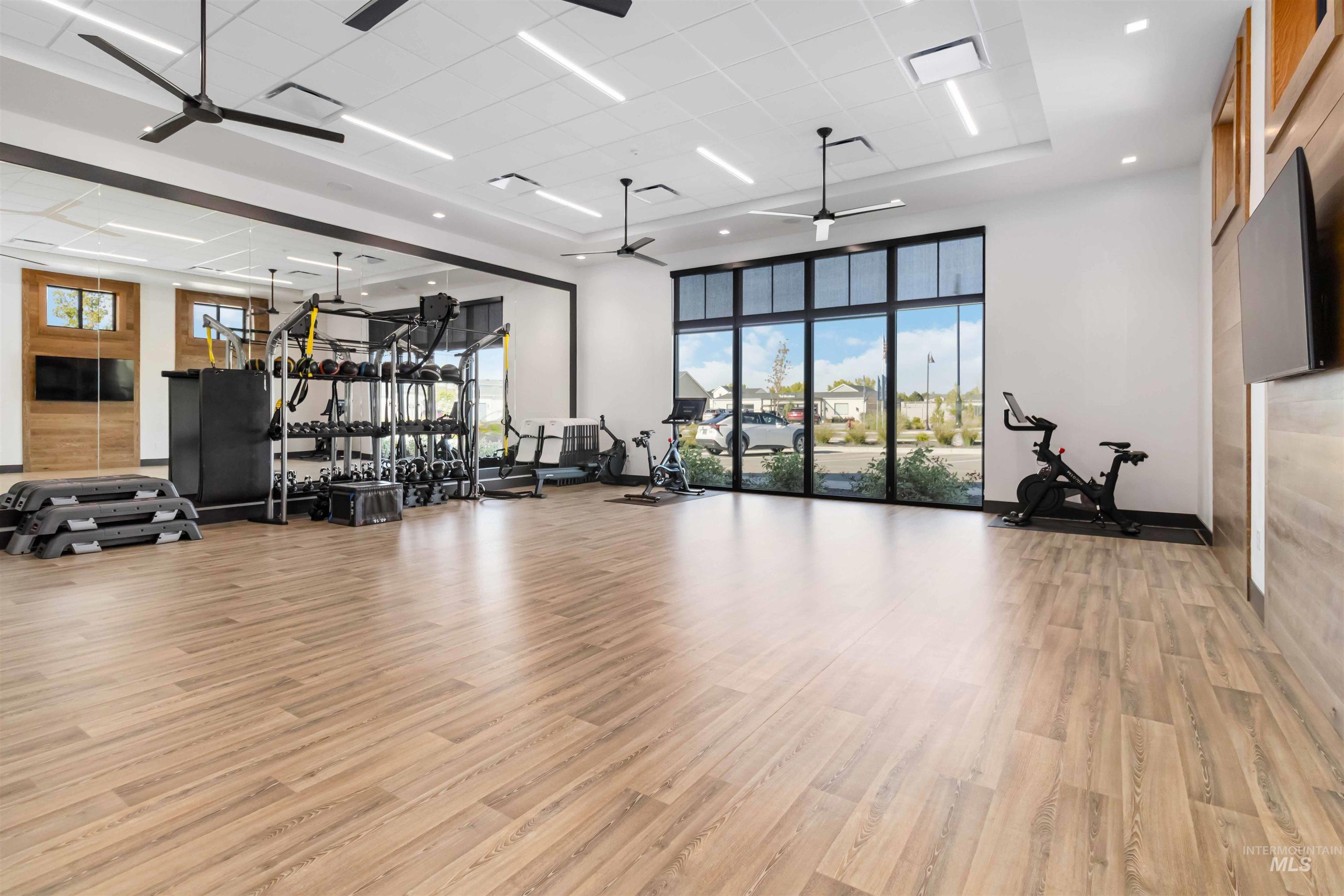 Exercise room featuring ceiling fan and a towering ceiling