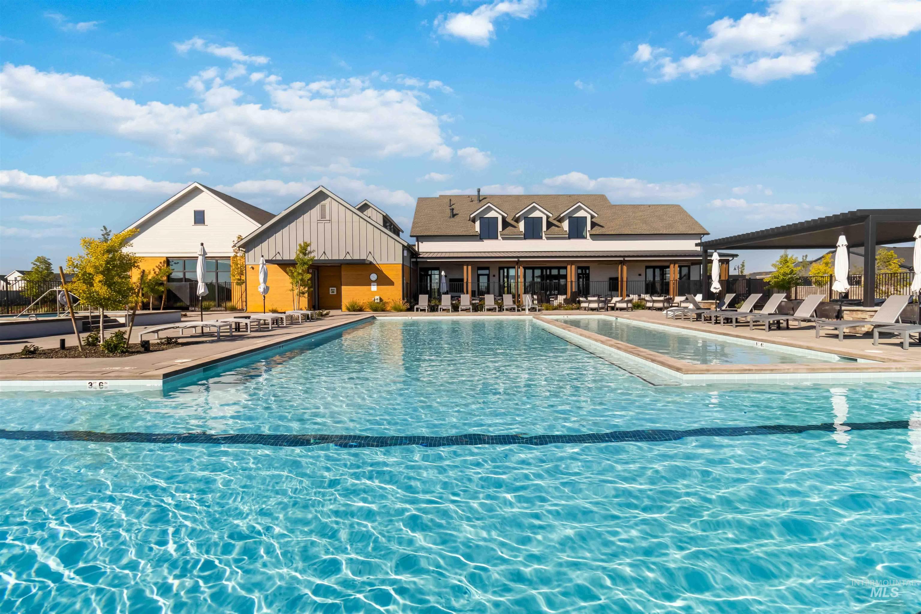 Community pool with a patio seating and large hot tub