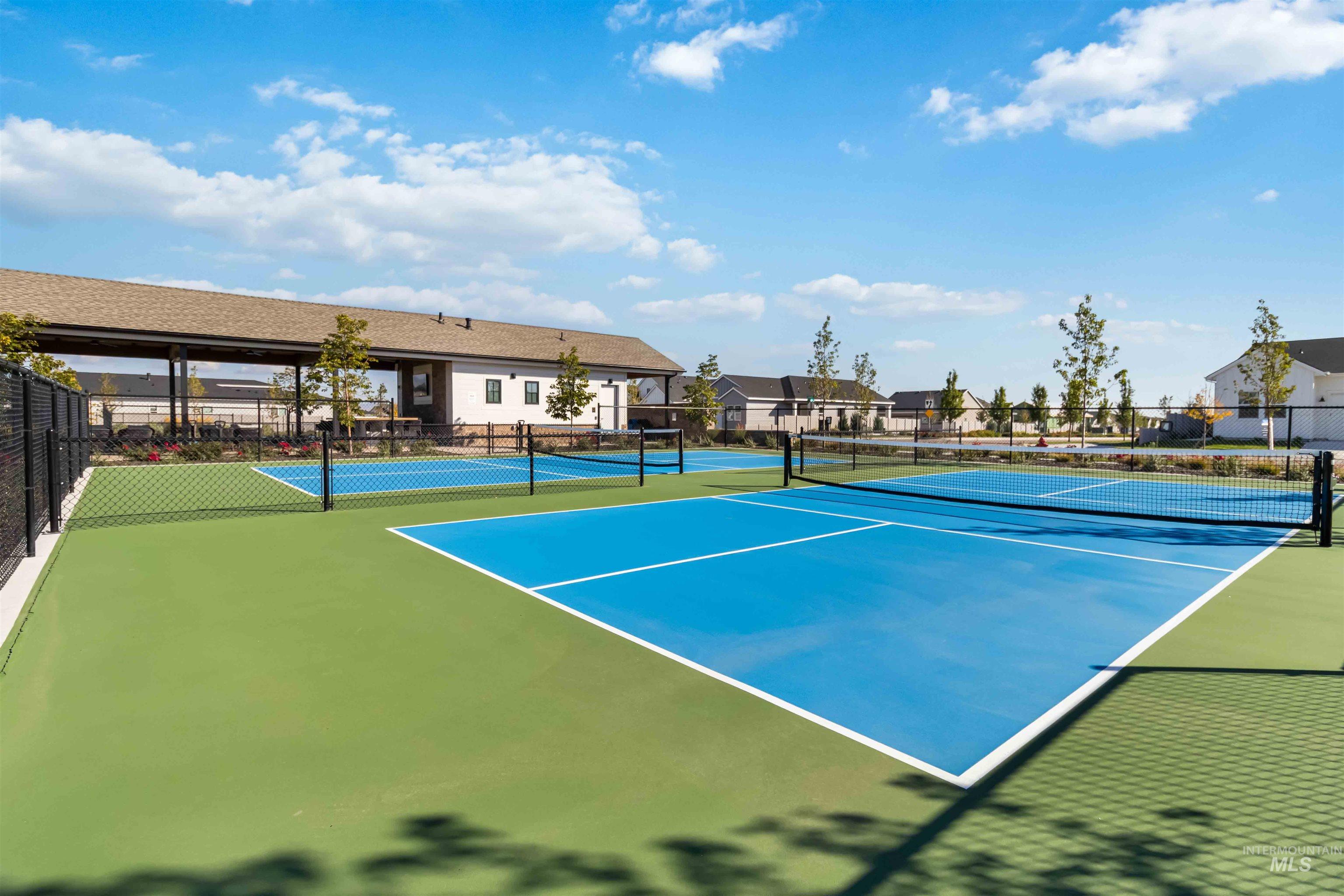 View of 4 pickle ball court featuring a residential view