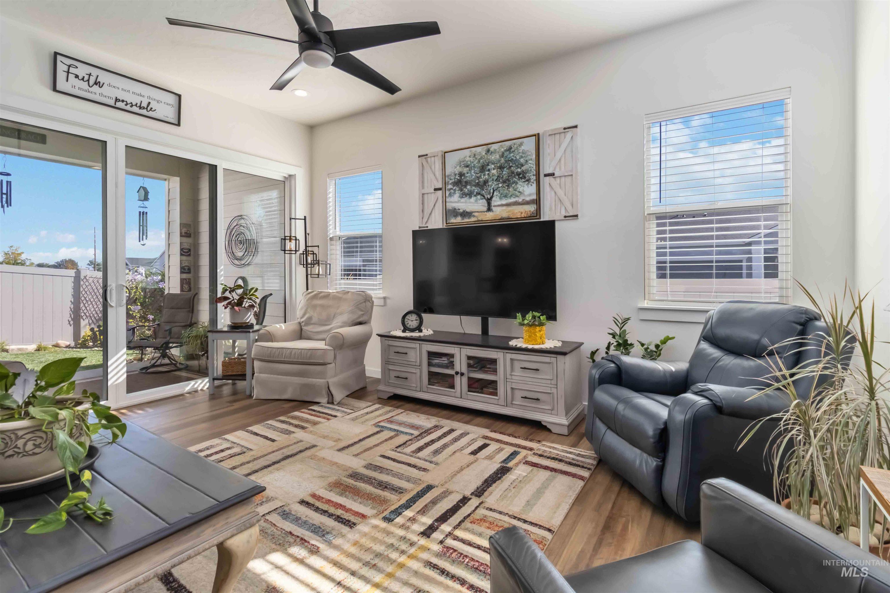 Living area featuring healthy amount of natural light, ceiling fan, wood finished floors, and recessed lighting. Large California style sliding doors to private covered patio and quaint back yard.