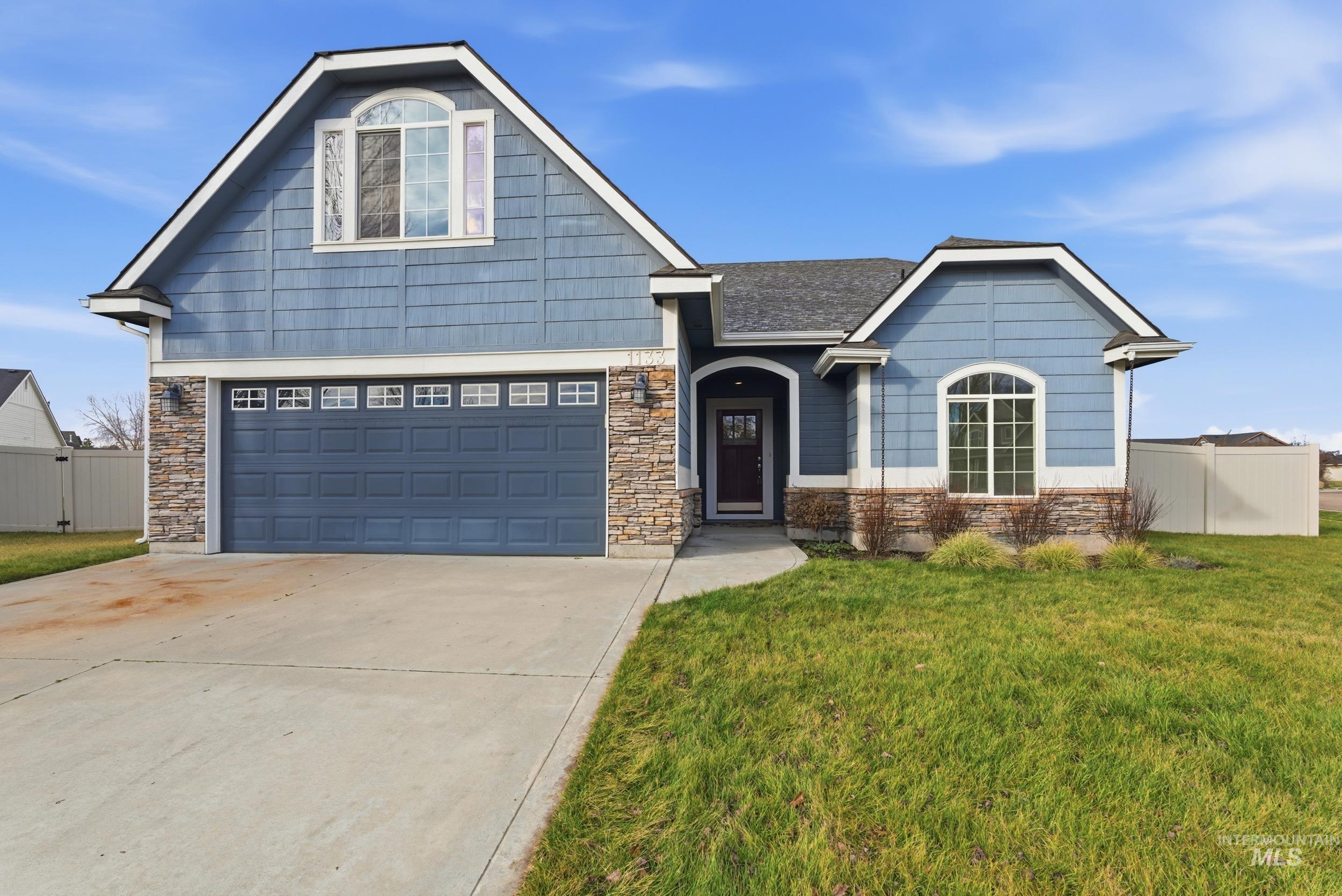 Craftsman-style house with driveway, stone siding, and an attached garage