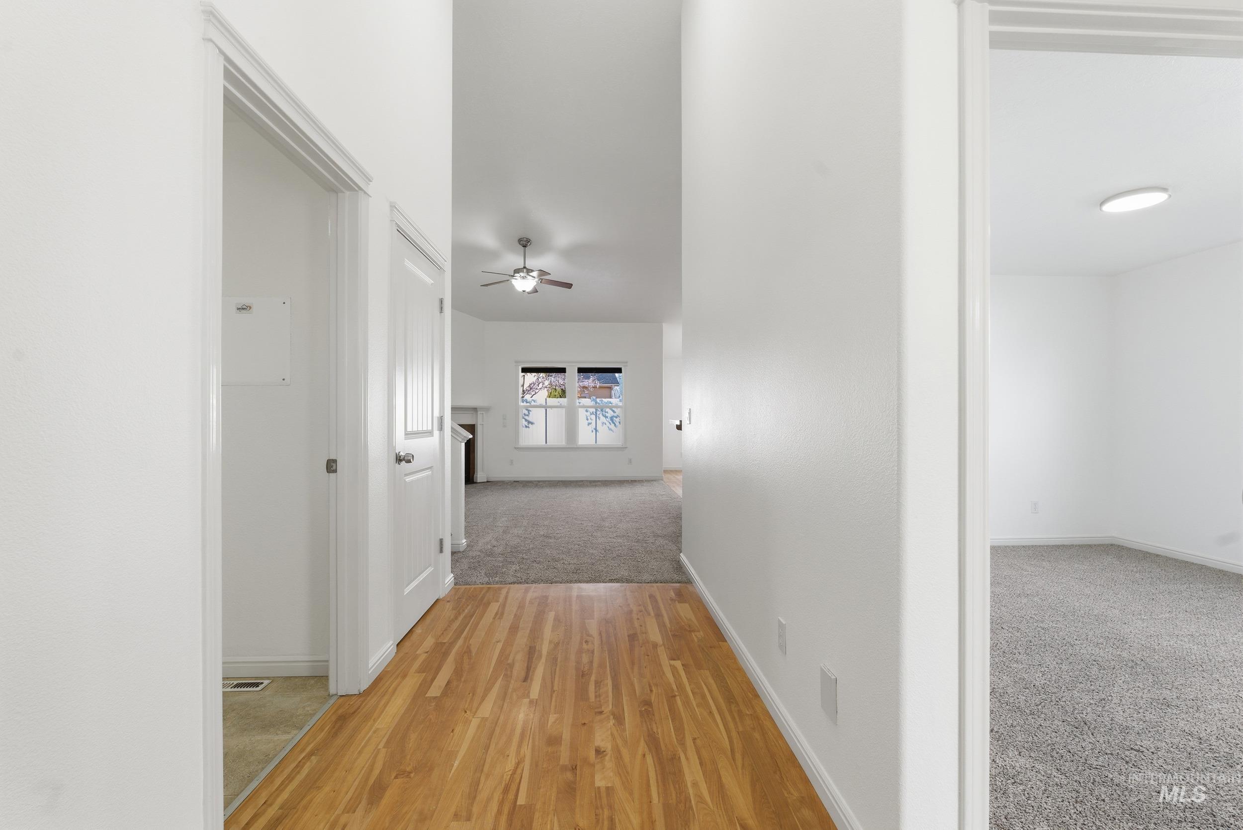 Hall featuring light colored carpet and light wood-style floors