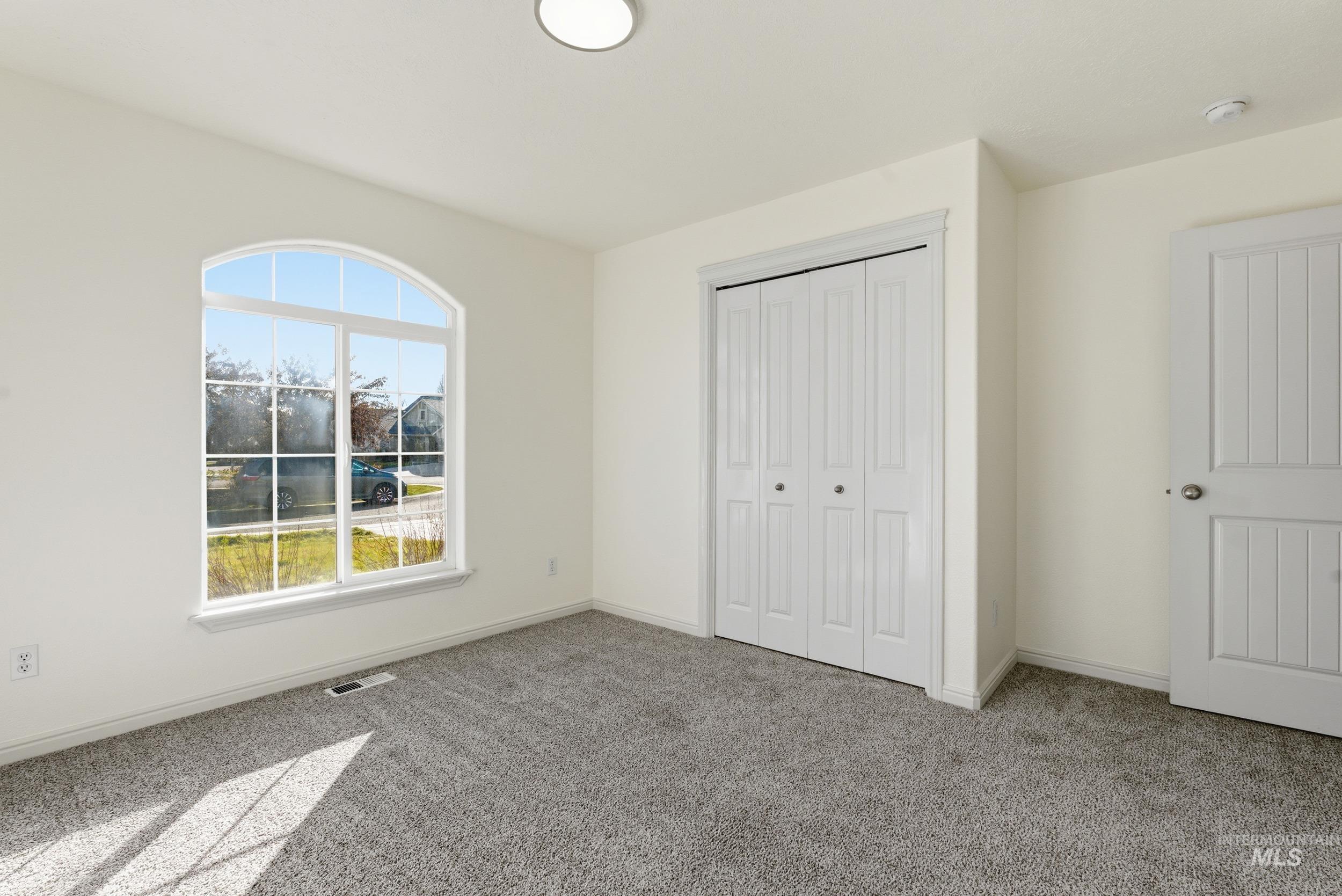 Unfurnished bedroom with light colored carpet and a closet
