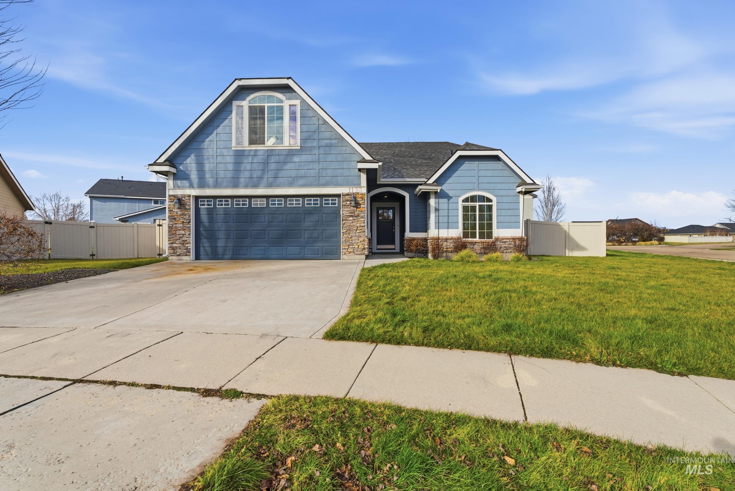 Craftsman inspired home with stone siding, driveway, and a shingled roof