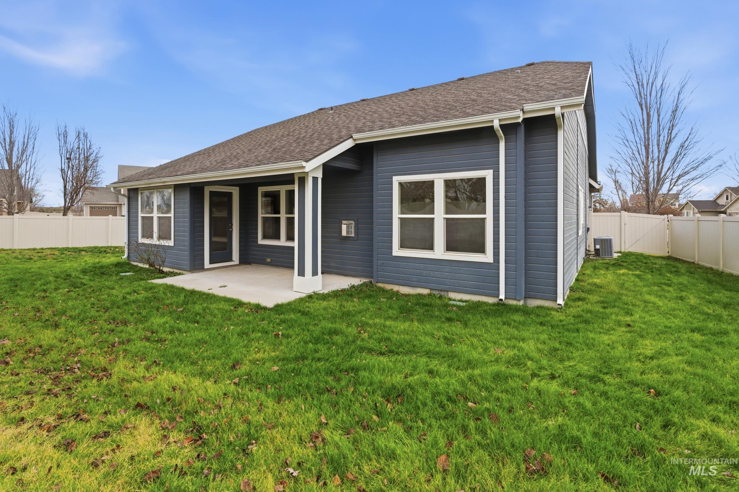 Rear view of property with a fenced backyard, a patio area, and roof with shingles