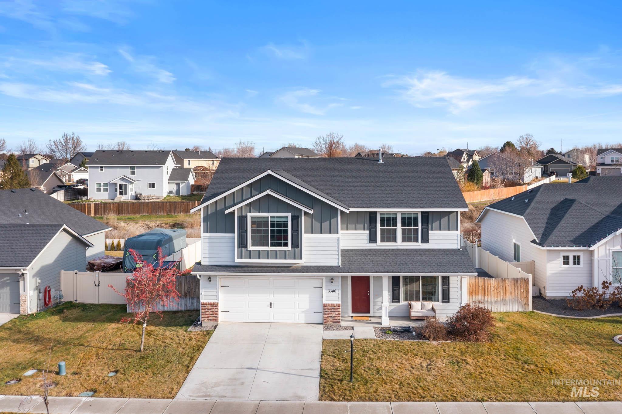 Traditional-style home featuring a residential view, board and batten siding, concrete driveway, and a garage