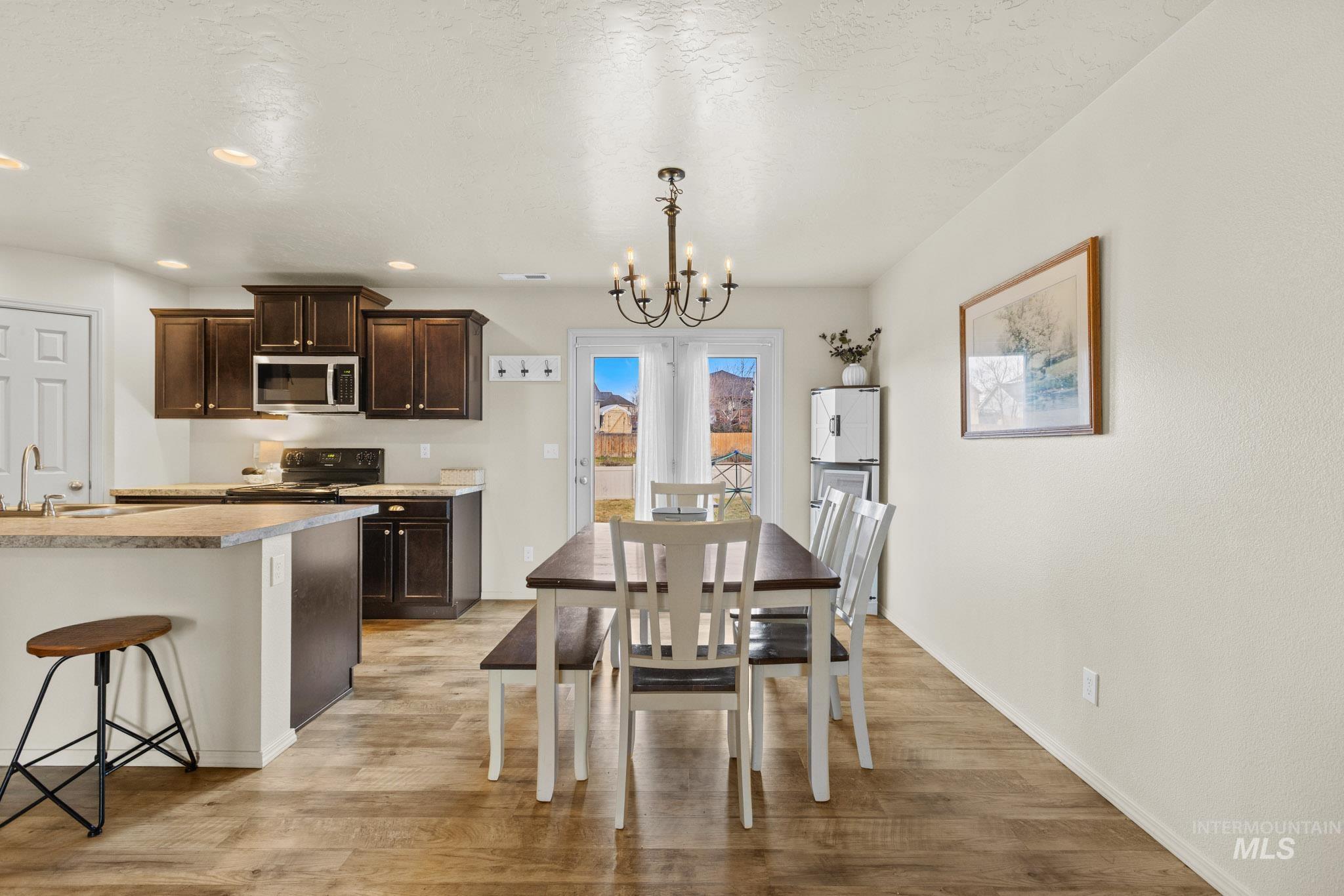 Dining area with a chandelier, light wood-type flooring, and recessed lighting