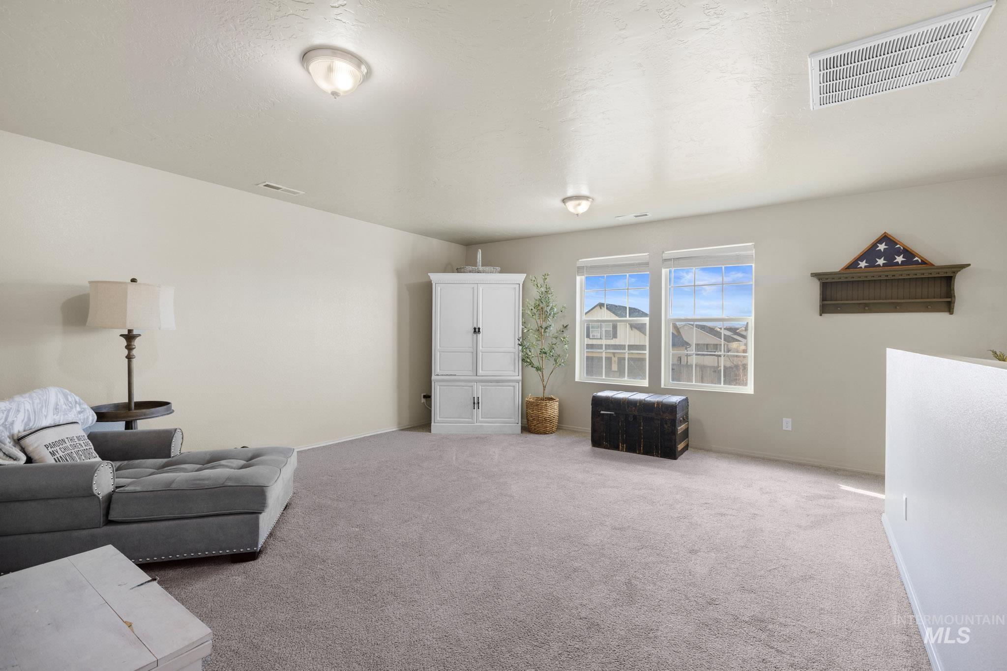 Living room featuring carpet flooring and a textured ceiling