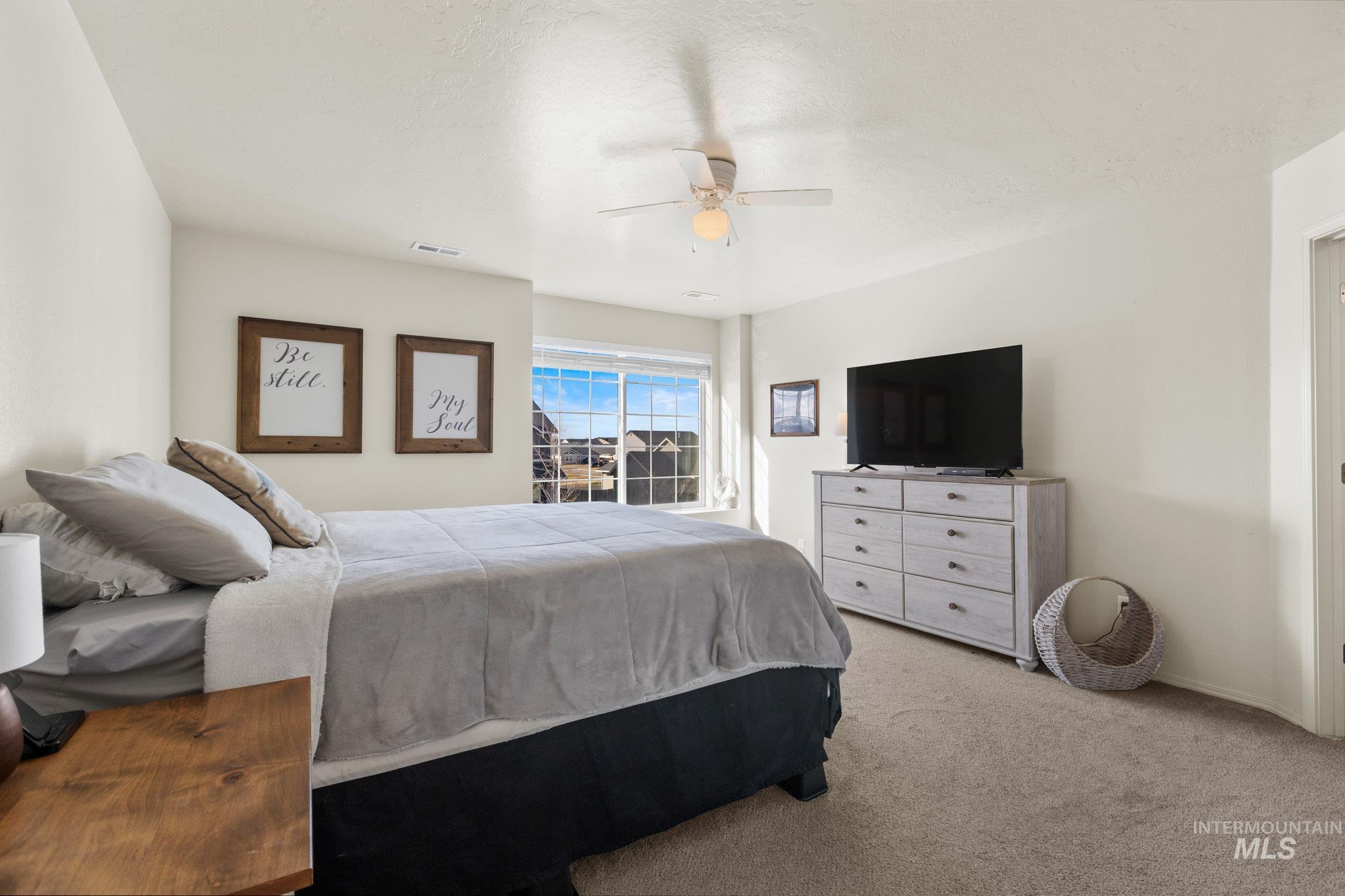 Carpeted bedroom featuring ceiling fan