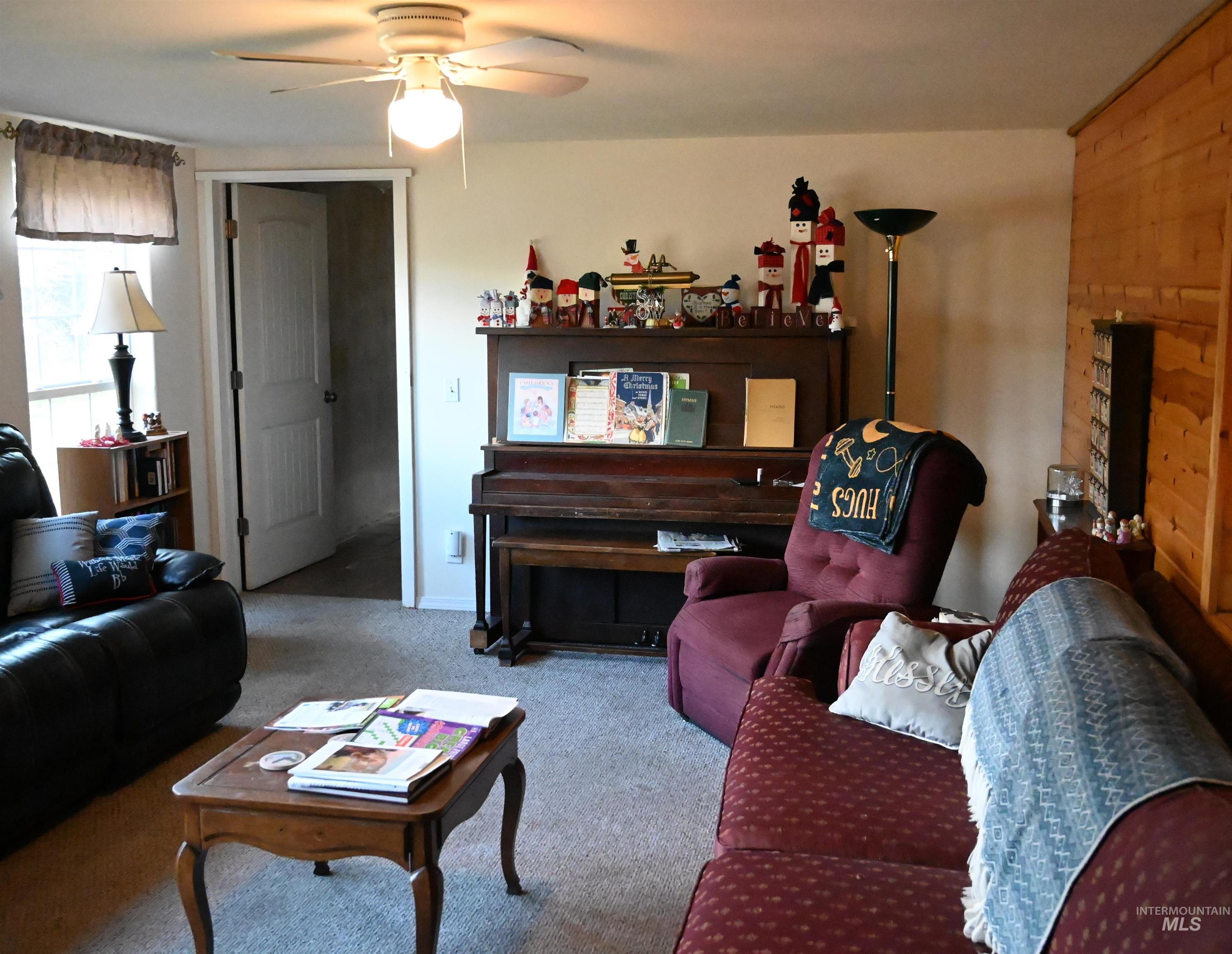 Carpeted living area with a ceiling fan