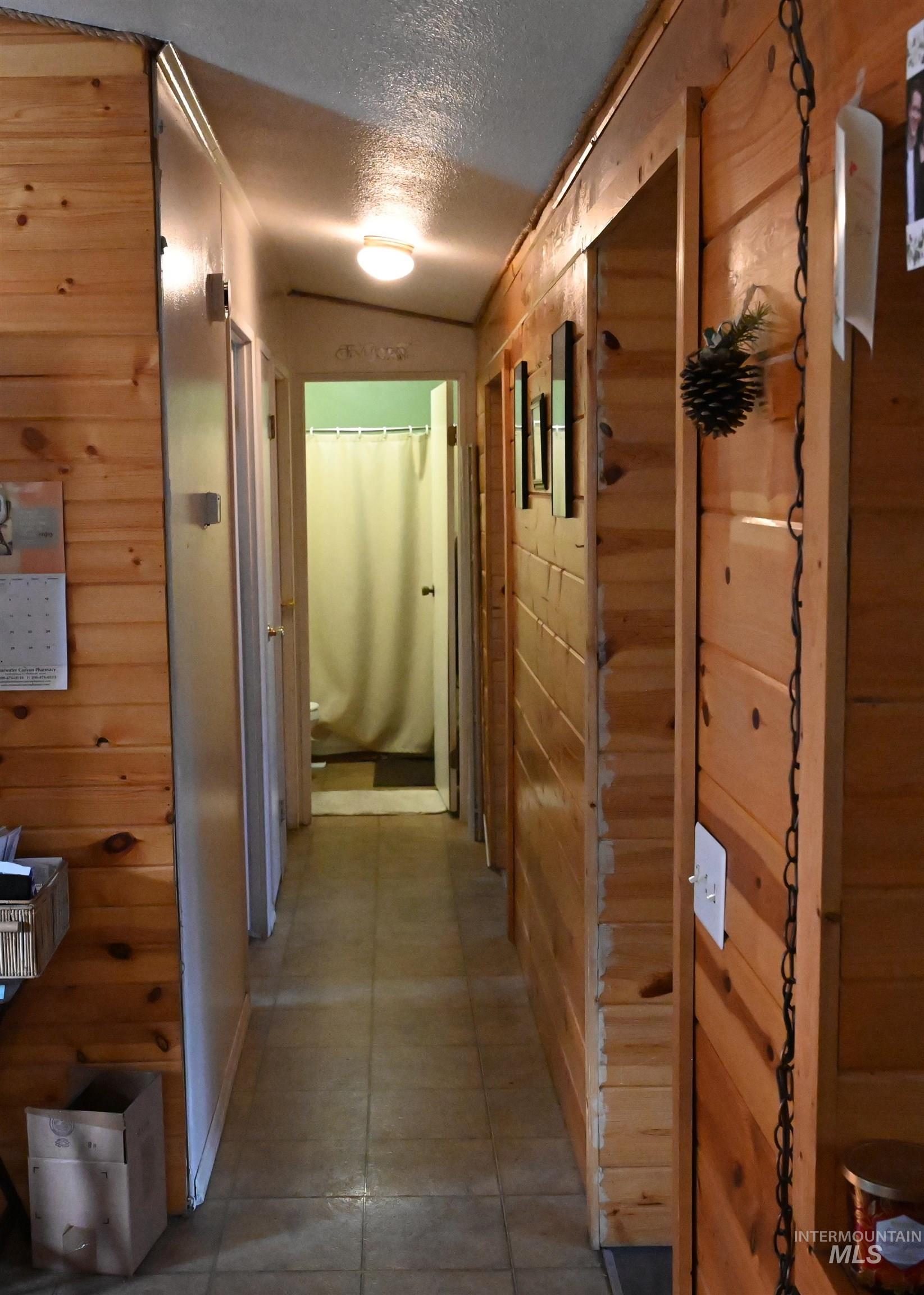 Hall with wood walls and a textured ceiling
