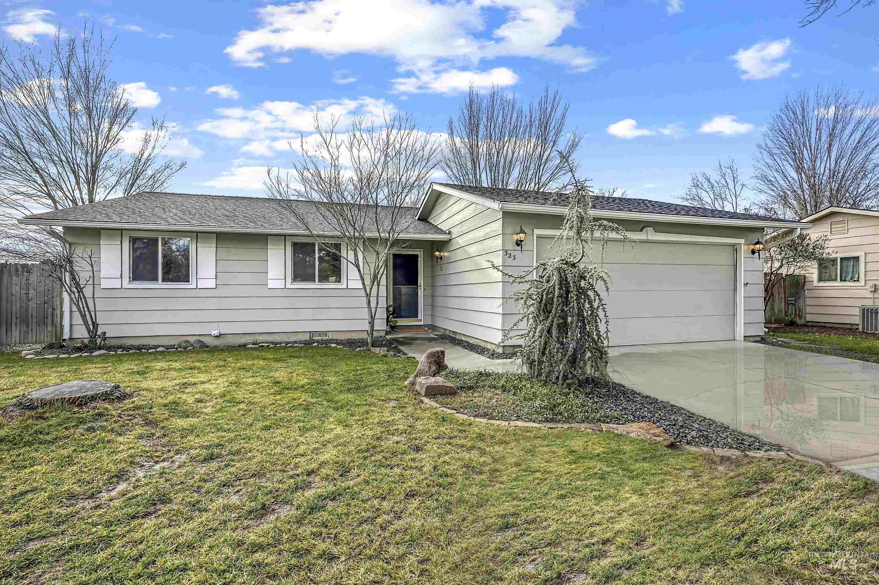 Ranch-style house featuring concrete driveway, a garage, and roof with shingles