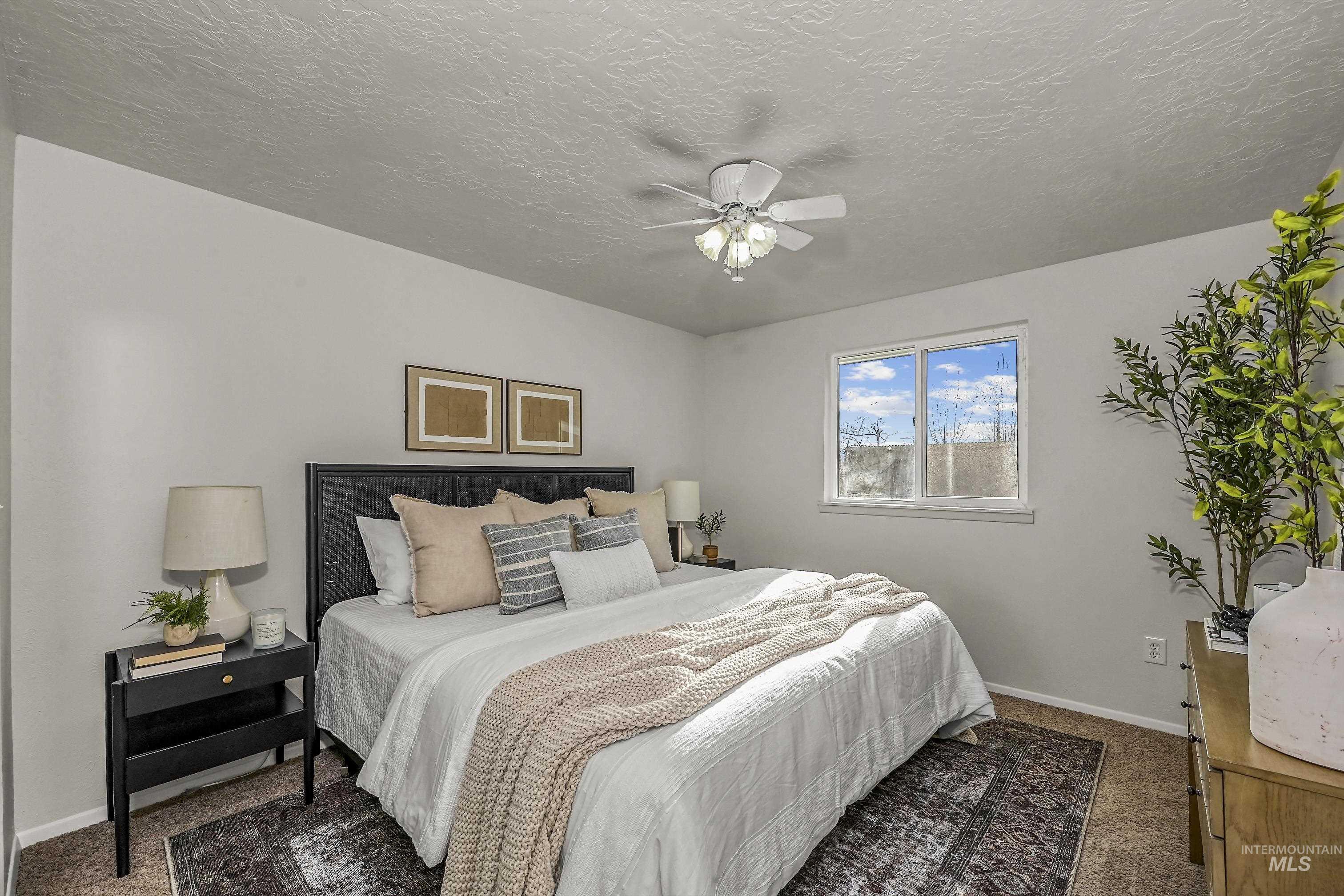 Bedroom featuring dark carpet, ceiling fan, and a textured ceiling
