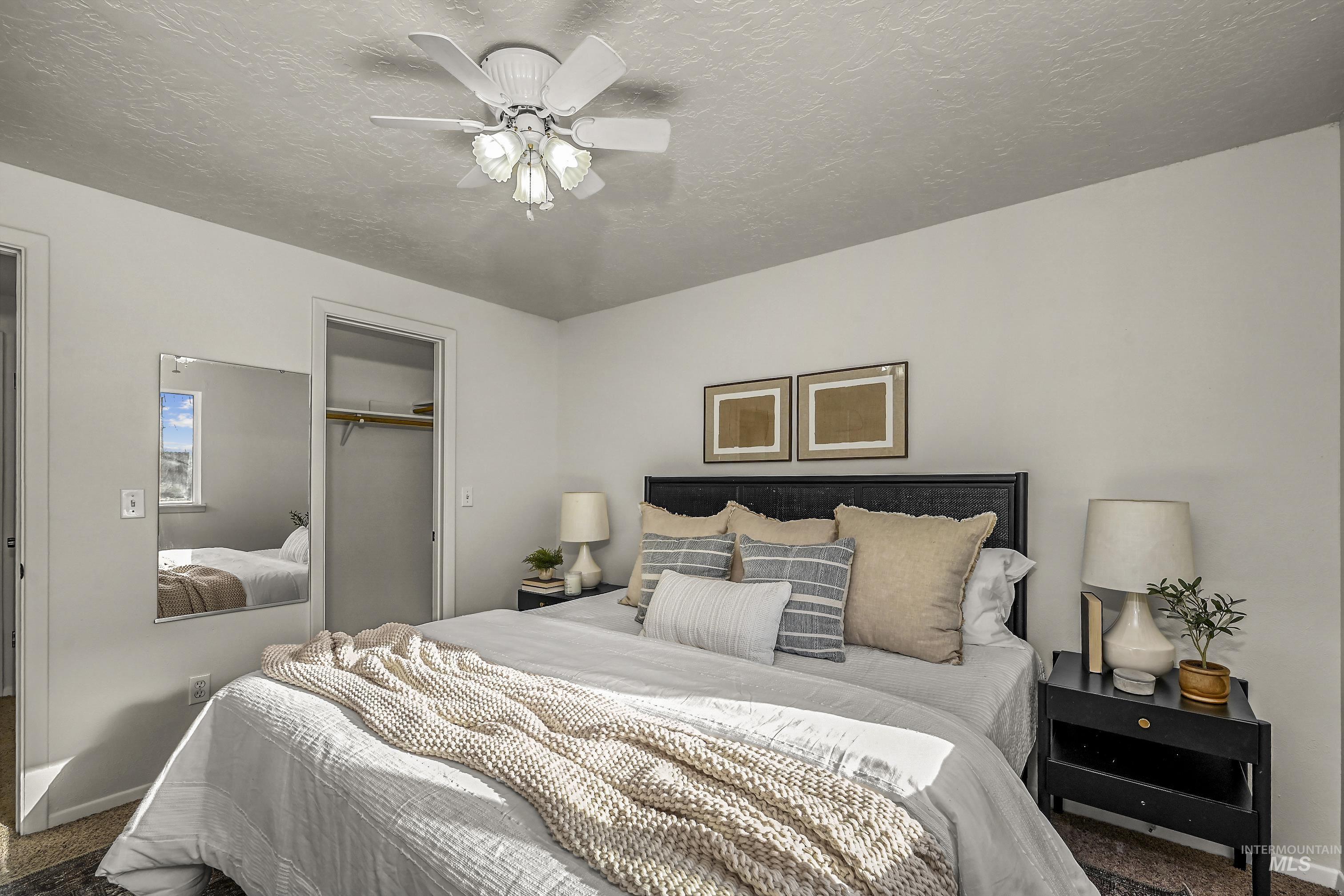 Bedroom featuring a closet, carpet floors, ceiling fan, and a textured ceiling