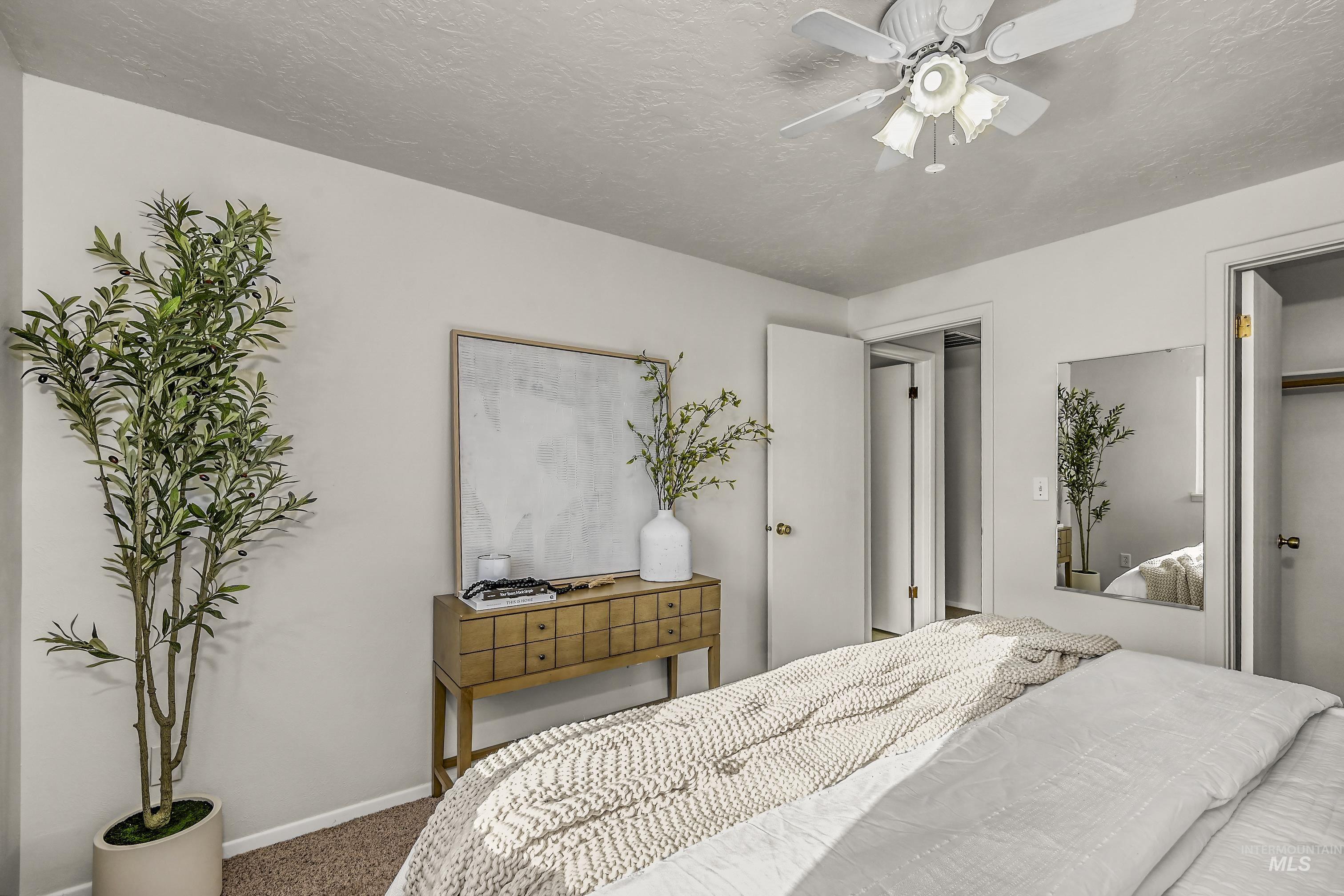 Bedroom with carpet flooring, a ceiling fan, a textured ceiling, and a closet