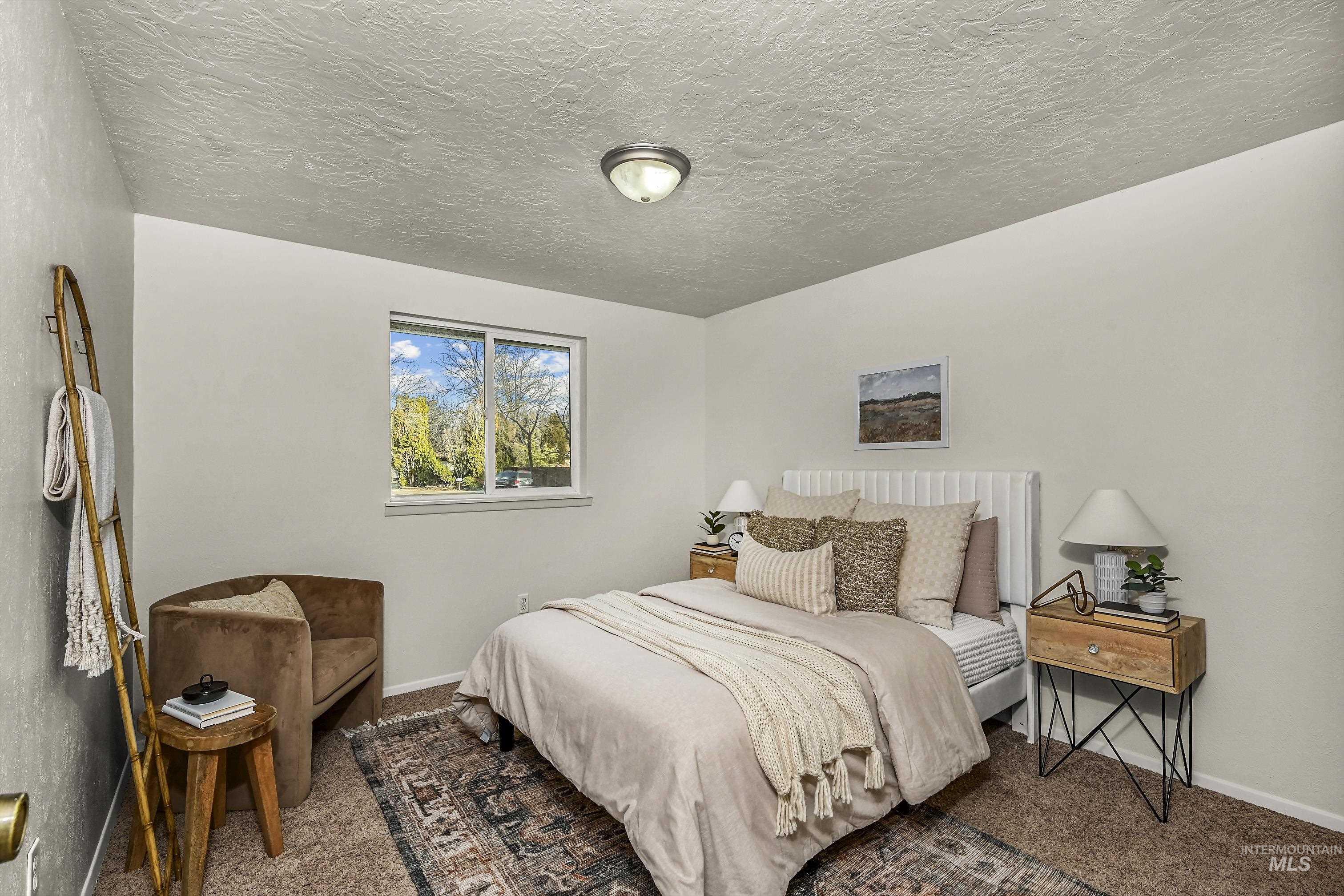 Bedroom featuring carpet flooring and a textured ceiling
