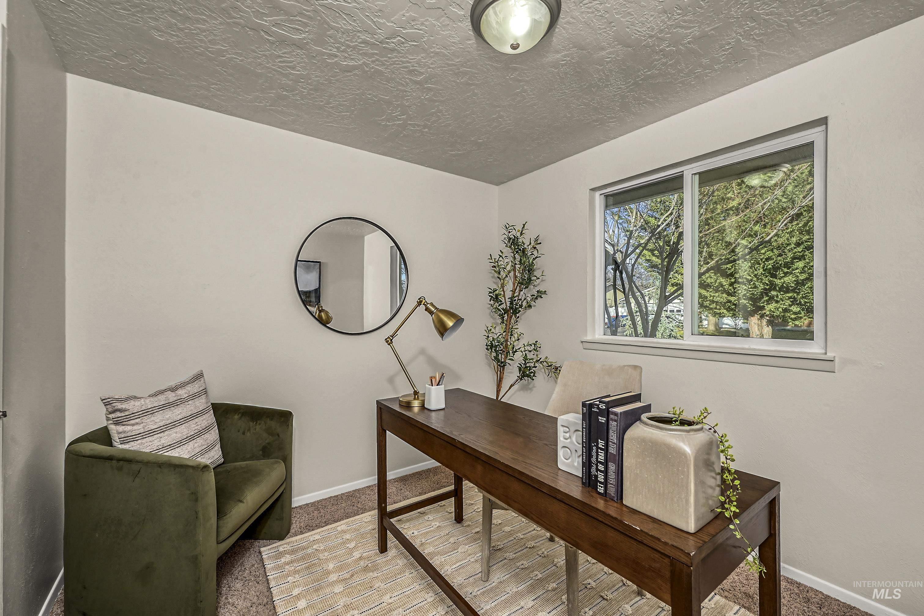 Carpeted bedroom featuring baseboards and a textured ceiling