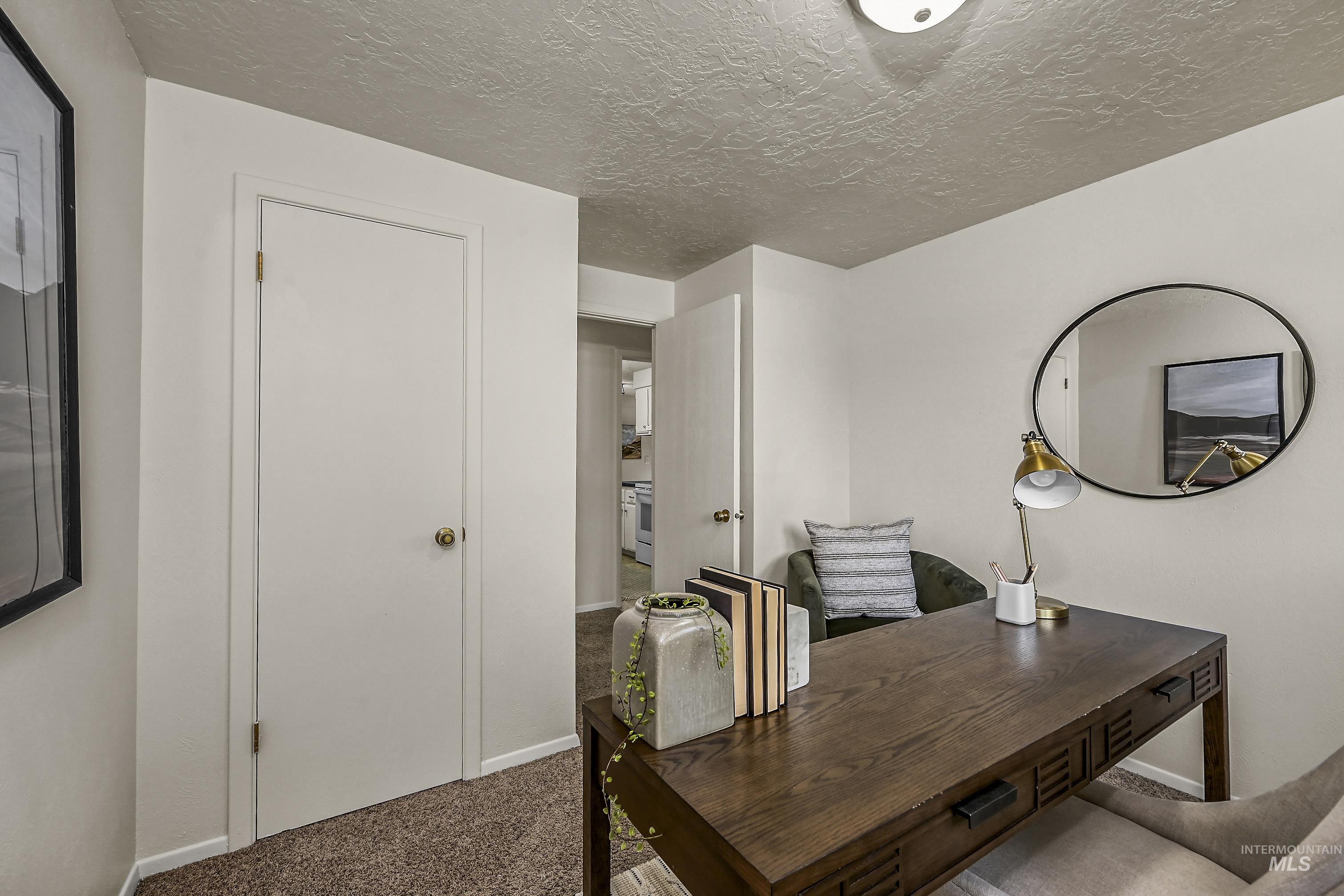 Carpeted bedroom with a textured ceiling and baseboards