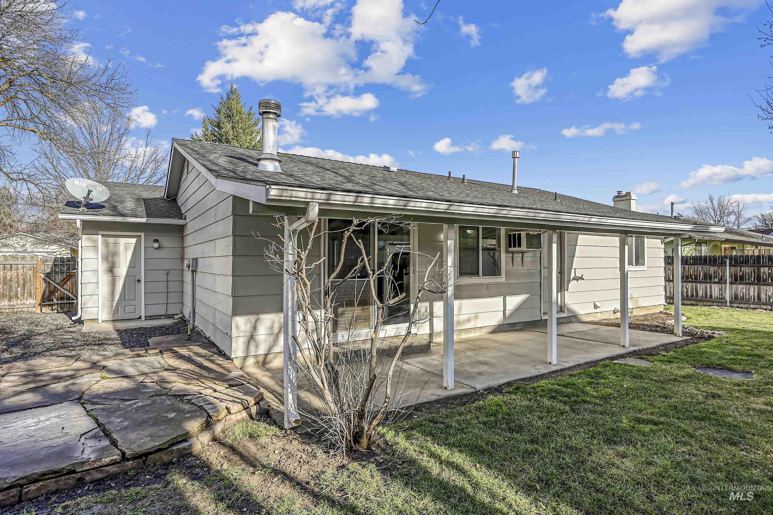 Rear view of property featuring a shingled roof and a patio