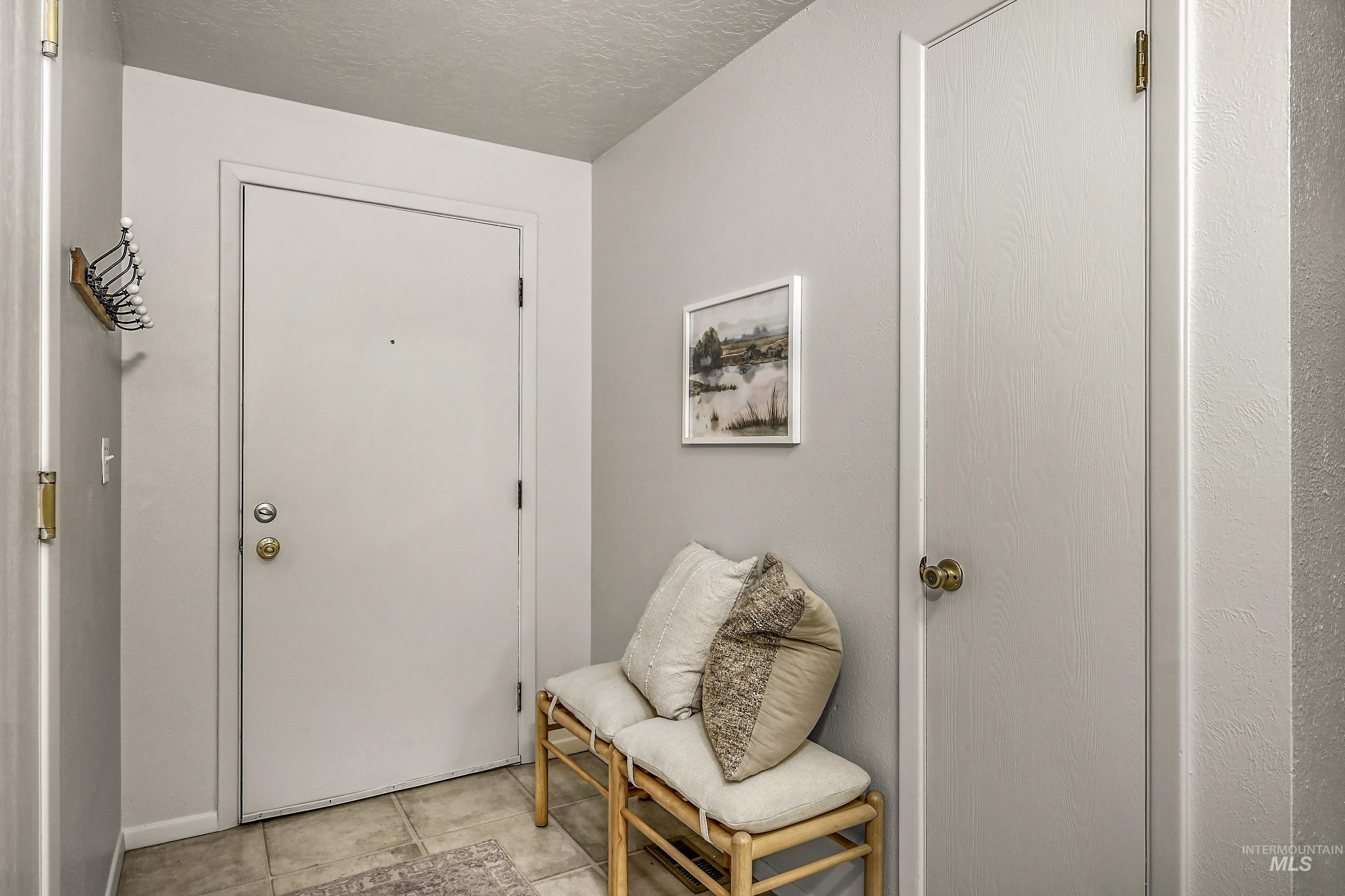 Tiled foyer entrance featuring a textured ceiling