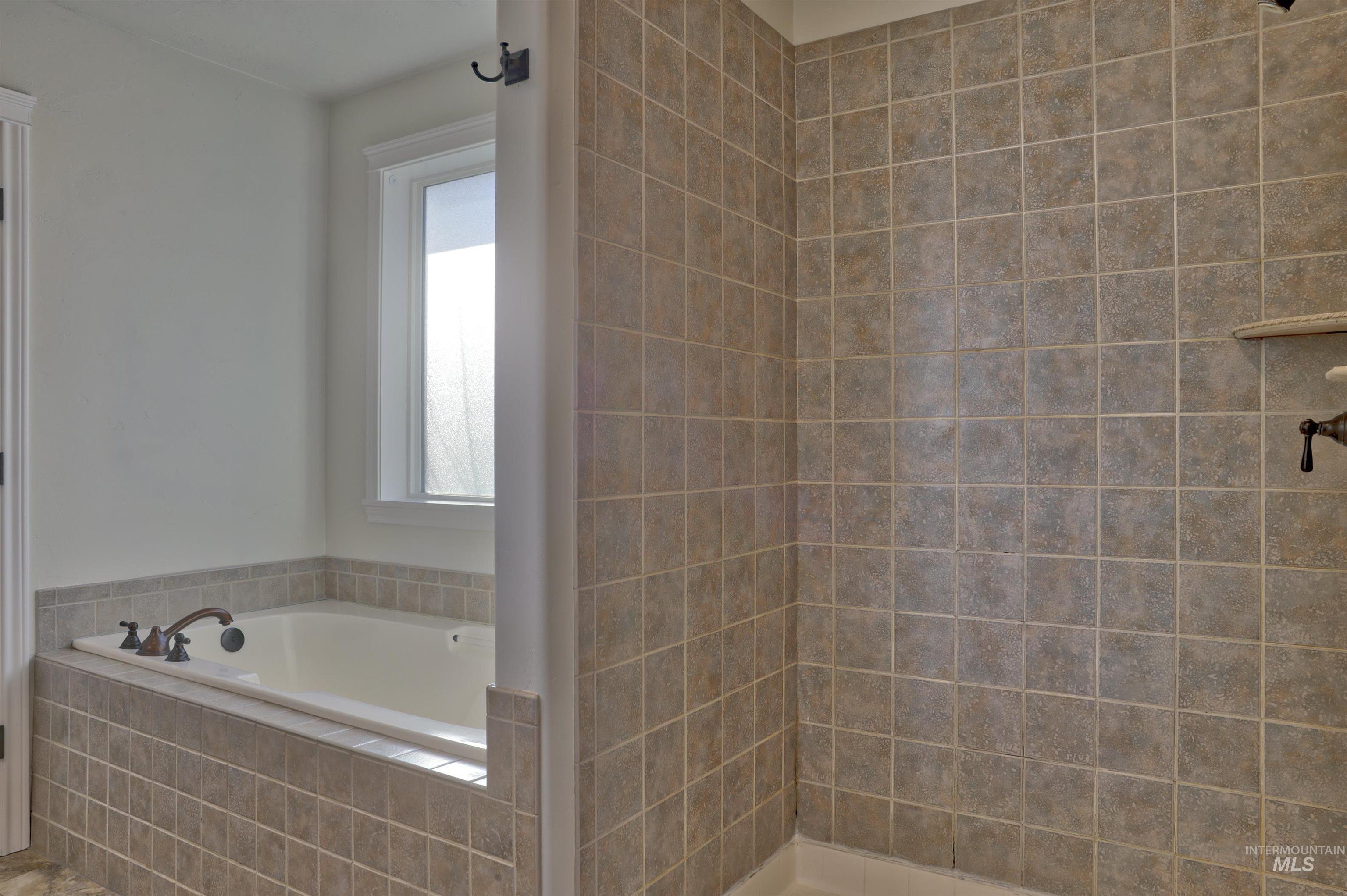Bathroom featuring a bath and a tile shower