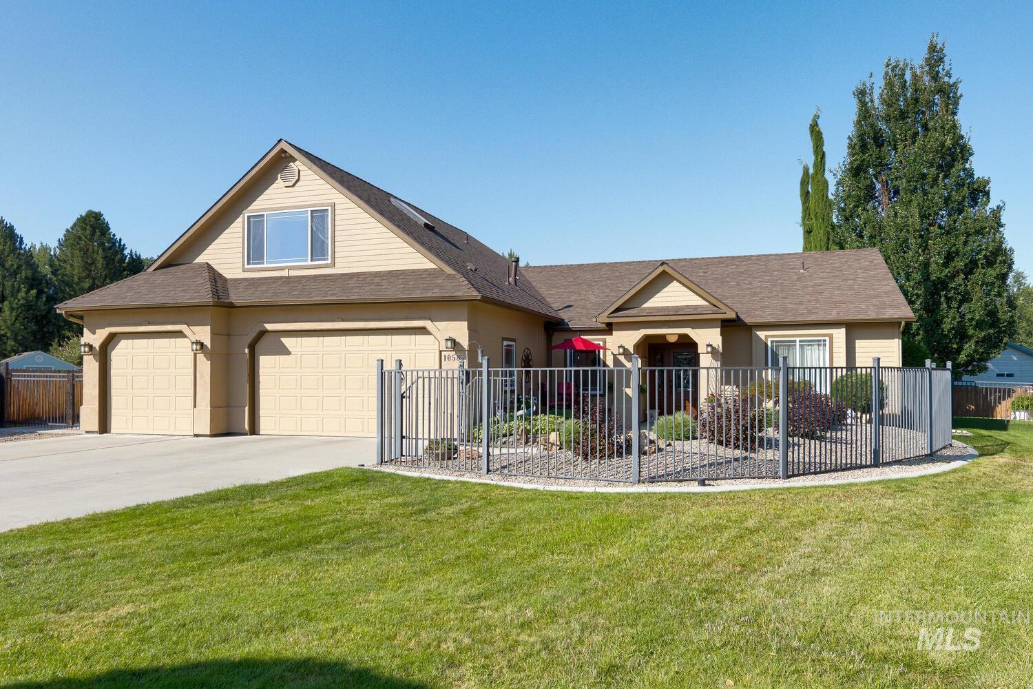 View of front of house featuring a fenced front yard, driveway, and a shingled roof