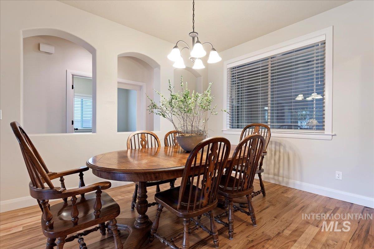 Dining room featuring a chandelier, light wood-type flooring, and arched walkways
