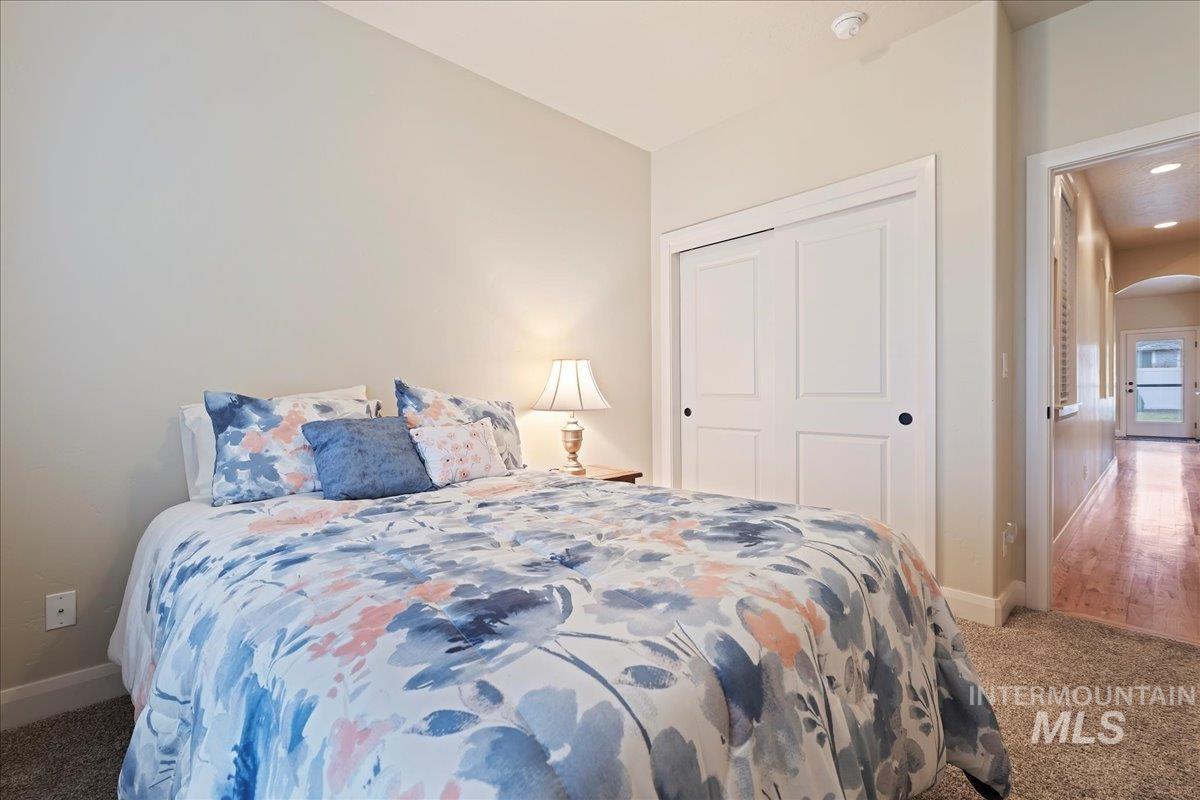 Carpeted bedroom featuring arched walkways and a closet