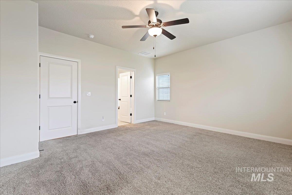 Unfurnished bedroom featuring light colored carpet and a ceiling fan