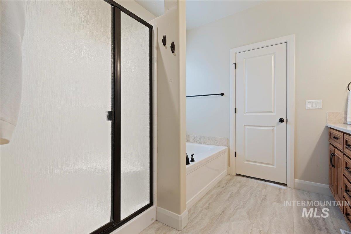 Full bath featuring a bath, a stall shower, and vanity